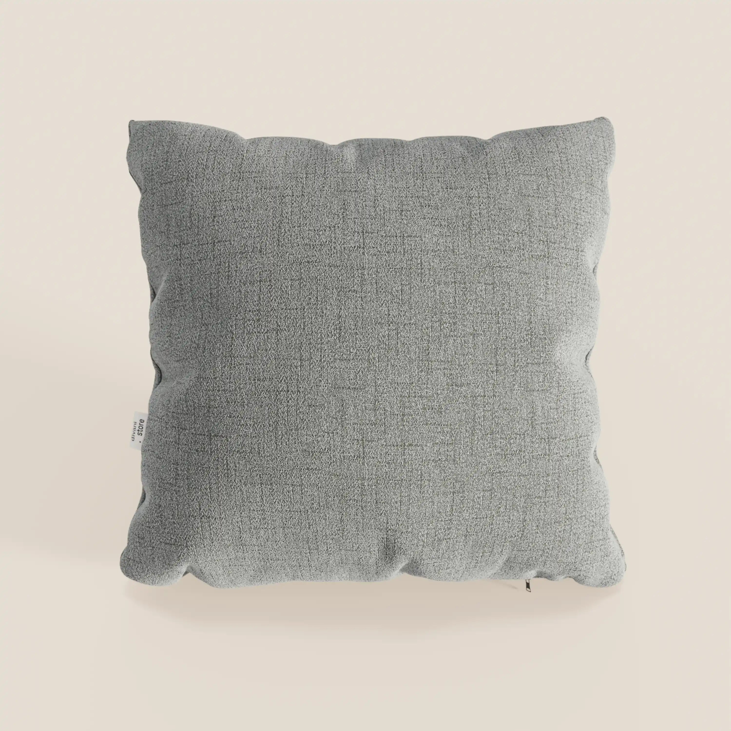 Il cuscino Felis 45x45 cm di Divani.Store, in grigio chiaro T03, ha una forma quadrata, un morbido tessuto idrorepellente, una texture sottile, bordi arrotondati e una piccola etichetta laterale bianca.