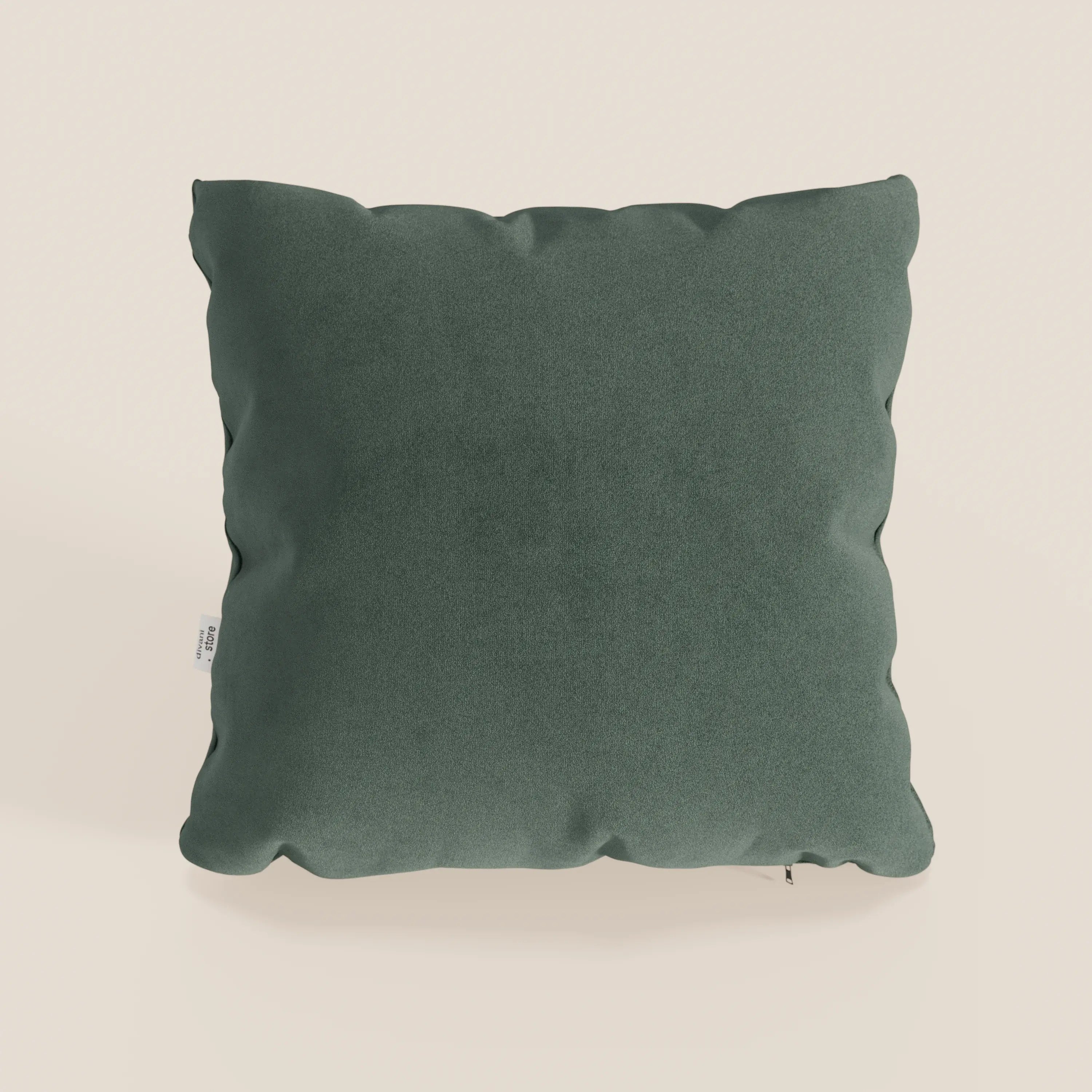 Un cuscino Jazz 45x45 in microfibra tecnica smacchiabile T11 verde di Divani.Store si staglia su uno sfondo beige chiaro. Ha una finitura morbida, vellutata e antigraffio, angoli arrotondati e una piccola etichetta bianca sul bordo sinistro.