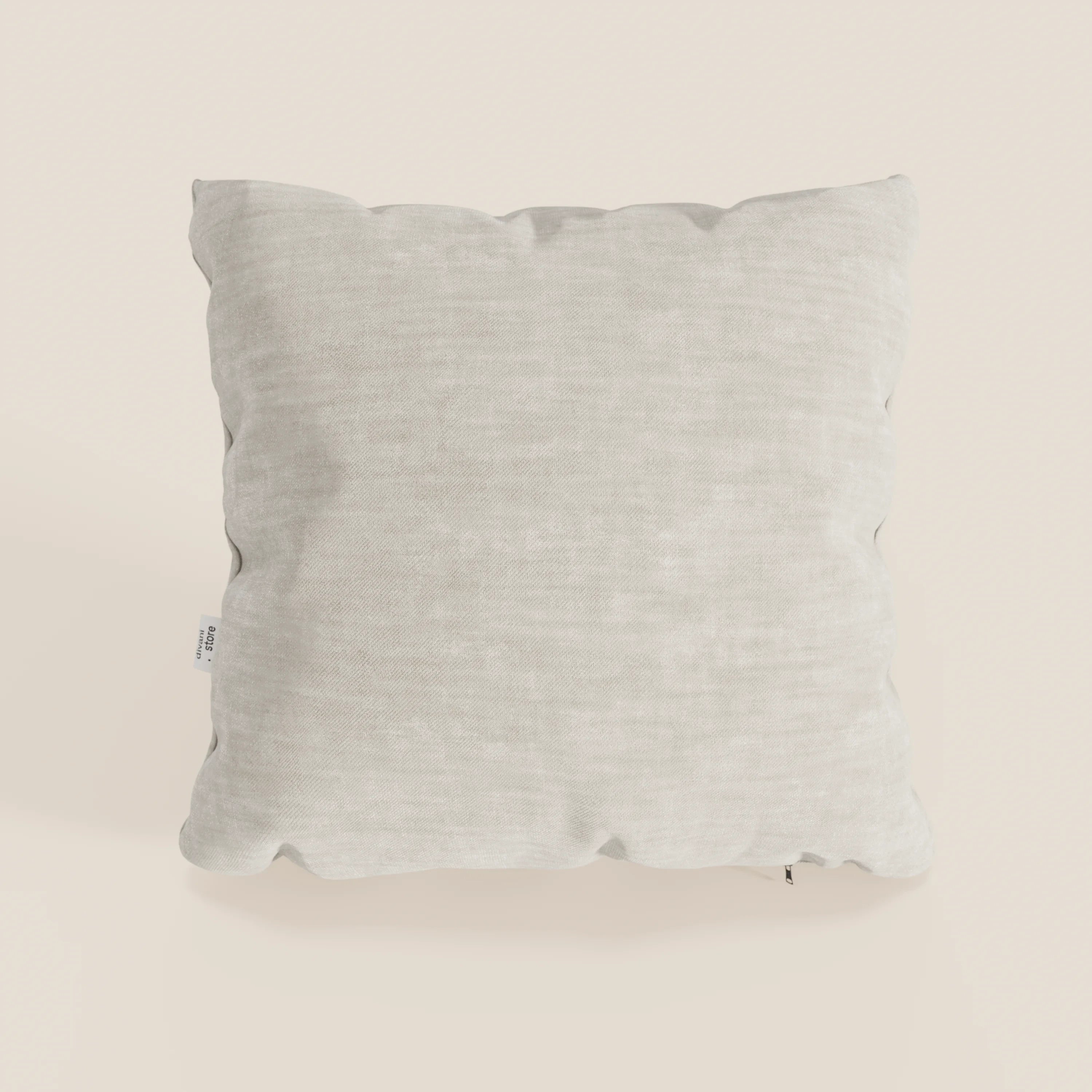 Il cuscino Sofia di Divani.Store, presentato in beige chiaro, è caratterizzato da un morbido e vellutato tessuto Easy Clean T35, resistente alle macchie e all'acqua. Il cuscino quadrato presenta leggere pieghe e una piccola etichetta bianca con testo nero sul lato sinistro.