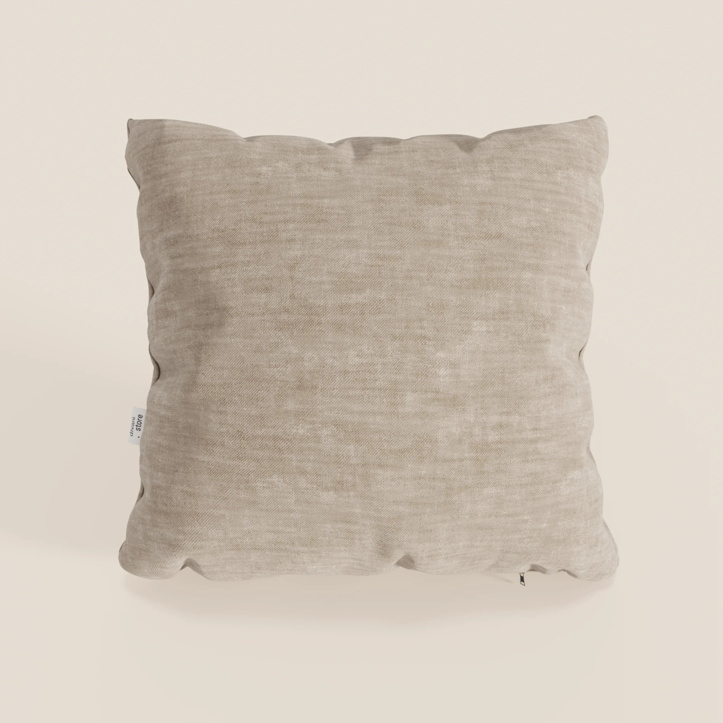 Il cuscino Sofia di Divani.Store è un cuscino decorativo quadrato di colore beige, realizzato in morbido velluto antimacchia Easy Clean T35. I bordi leggermente arrotondati e l'aspetto felpato lo rendono invitante; una piccola etichetta bianca compare sul lato sinistro.
