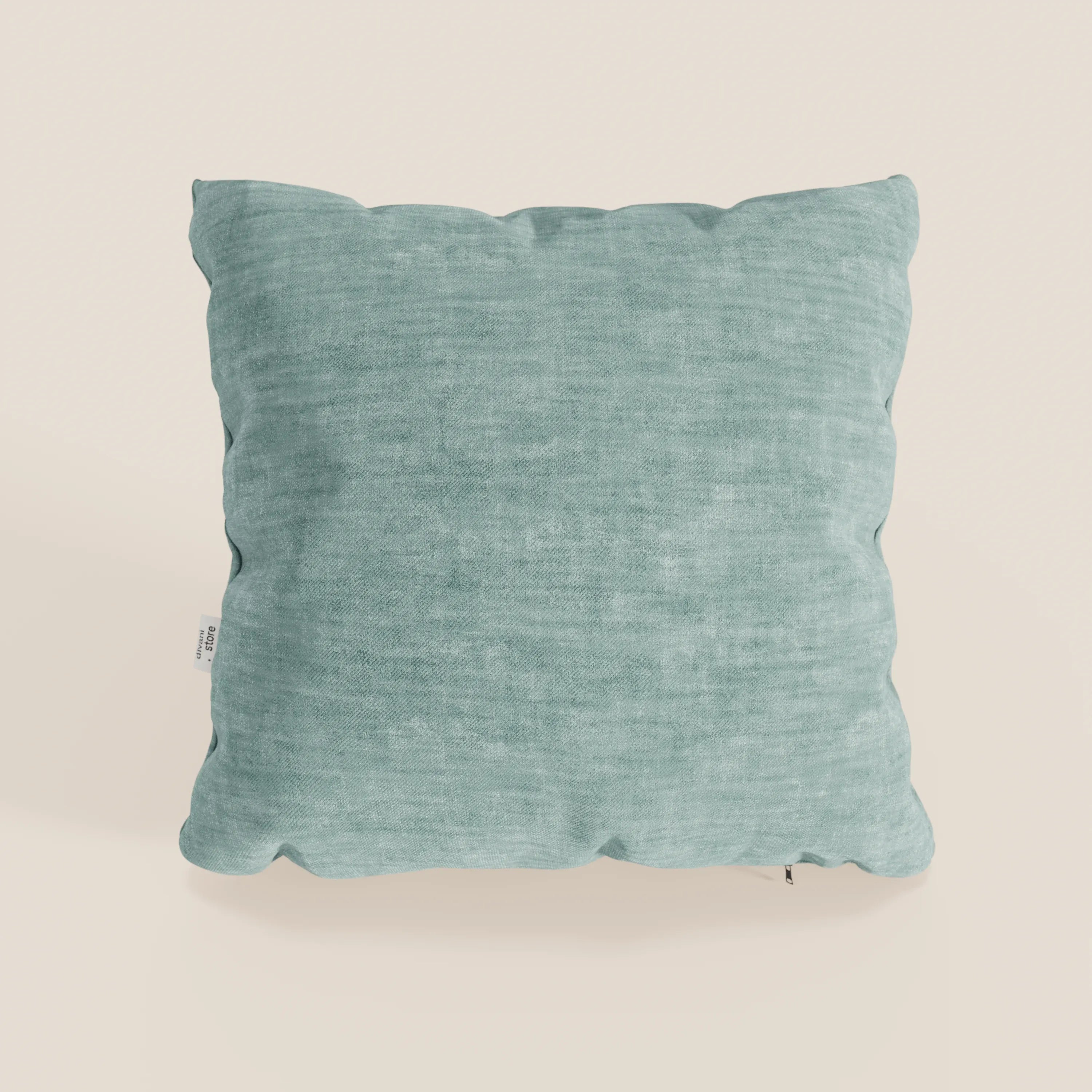 Il cuscino Sofia di Divani.Store, qui in colore verde acqua, è caratterizzato da una forma quadrata e da un morbido velluto T35 Easy Clean, resistente alle macchie e all'acqua. Include una piccola targhetta laterale bianca ed è posizionato su uno sfondo beige chiaro.