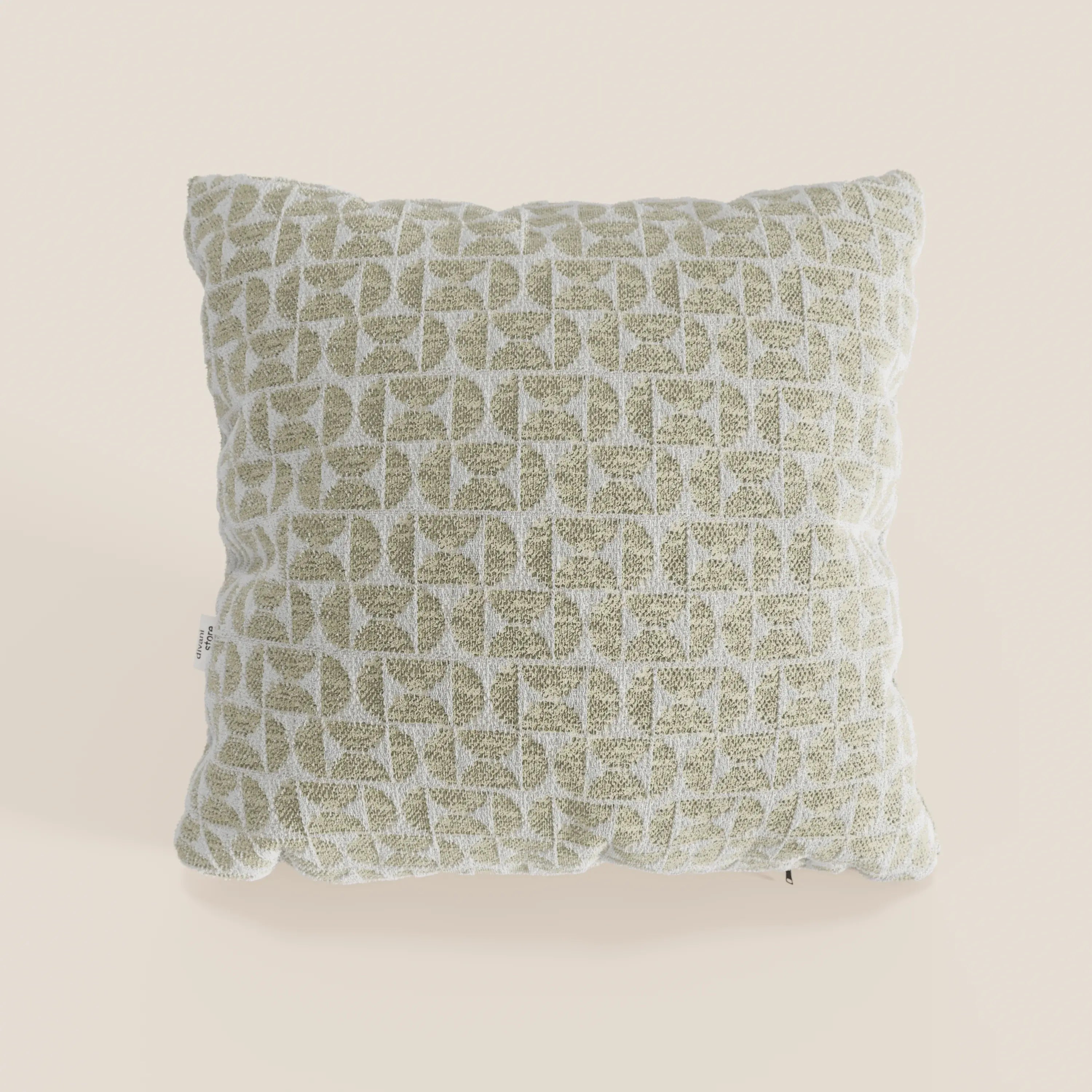 Il cuscino Naxos Decoro 45x45 in lino di Divani.Store presenta un motivo geometrico in rilievo nei toni del verde oliva chiaro e del bianco sporco su sfondo beige, con tessuto morbido, angoli leggermente arrotondati e una discreta etichetta laterale.
