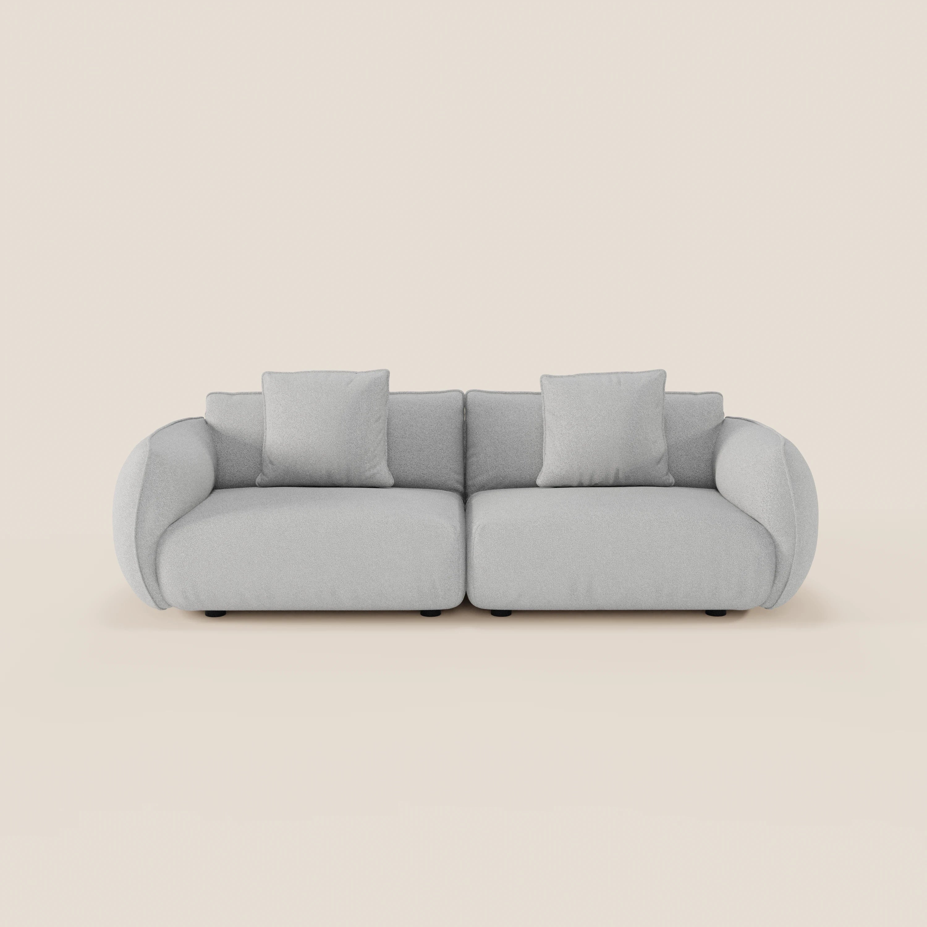 Il divano Nimbus 3 posti modulare e componibile di Divani.Store, un moderno divano modulare grigio chiaro con braccioli arrotondati e tre cuscini quadrati, si colloca su uno sfondo beige semplice per un look elegante e minimalista.