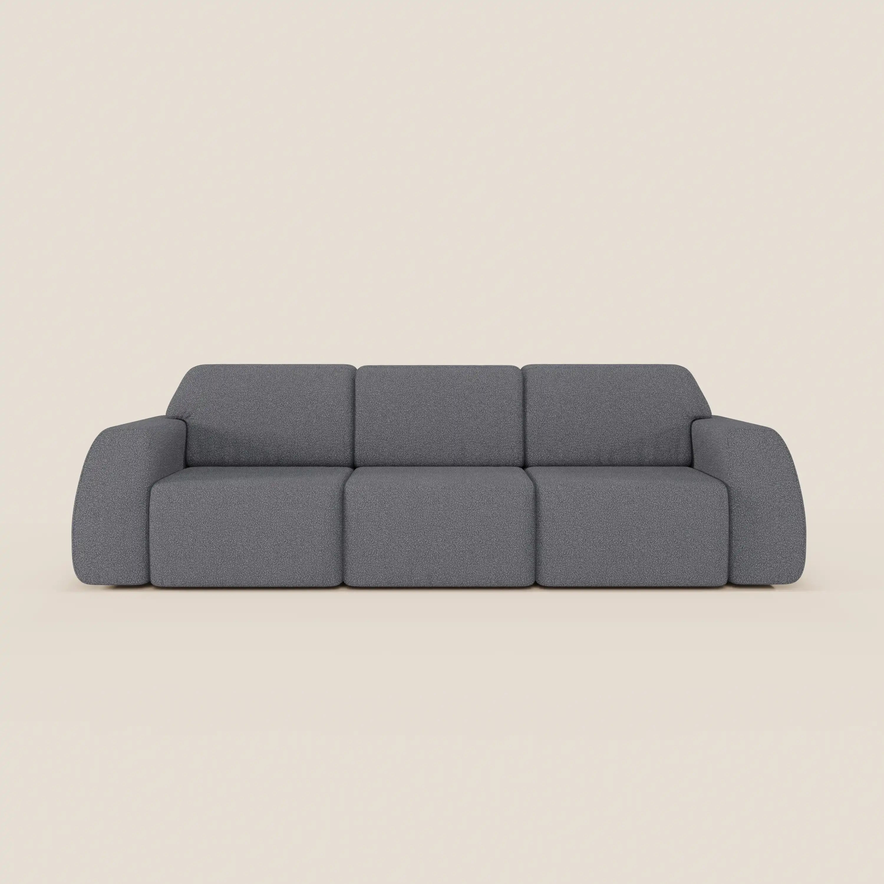 Il divano Orbit con 3 sedute scorrevoli e allungabili in tessuto effetto cotone smacchiabile T33 di Divani.Store è caratterizzato da un design moderno e minimalista di colore grigio con ampi braccioli arrotondati e una morbida imbottitura, su uno sfondo beige chiaro.