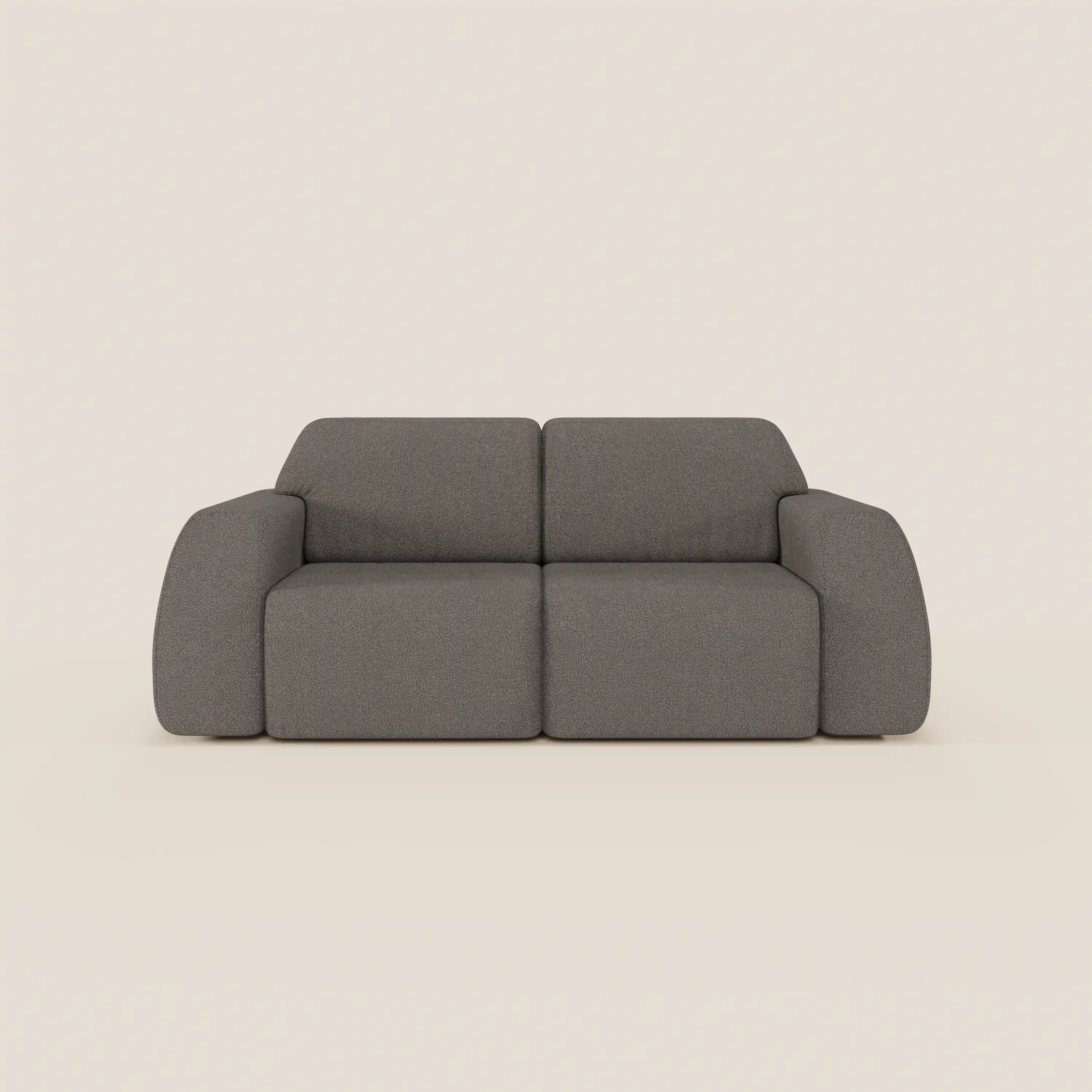 Il divano Orbit 2 e 3 posti di Divani.Store è caratterizzato da un look moderno e minimalista con tessuto grigio effetto cotone T33, facile da pulire, linee squadrate, braccioli arrotondati, schienali bassi, sedute morbide e assenza di gambe visibili, perfetto su uno sfondo beige chiaro.