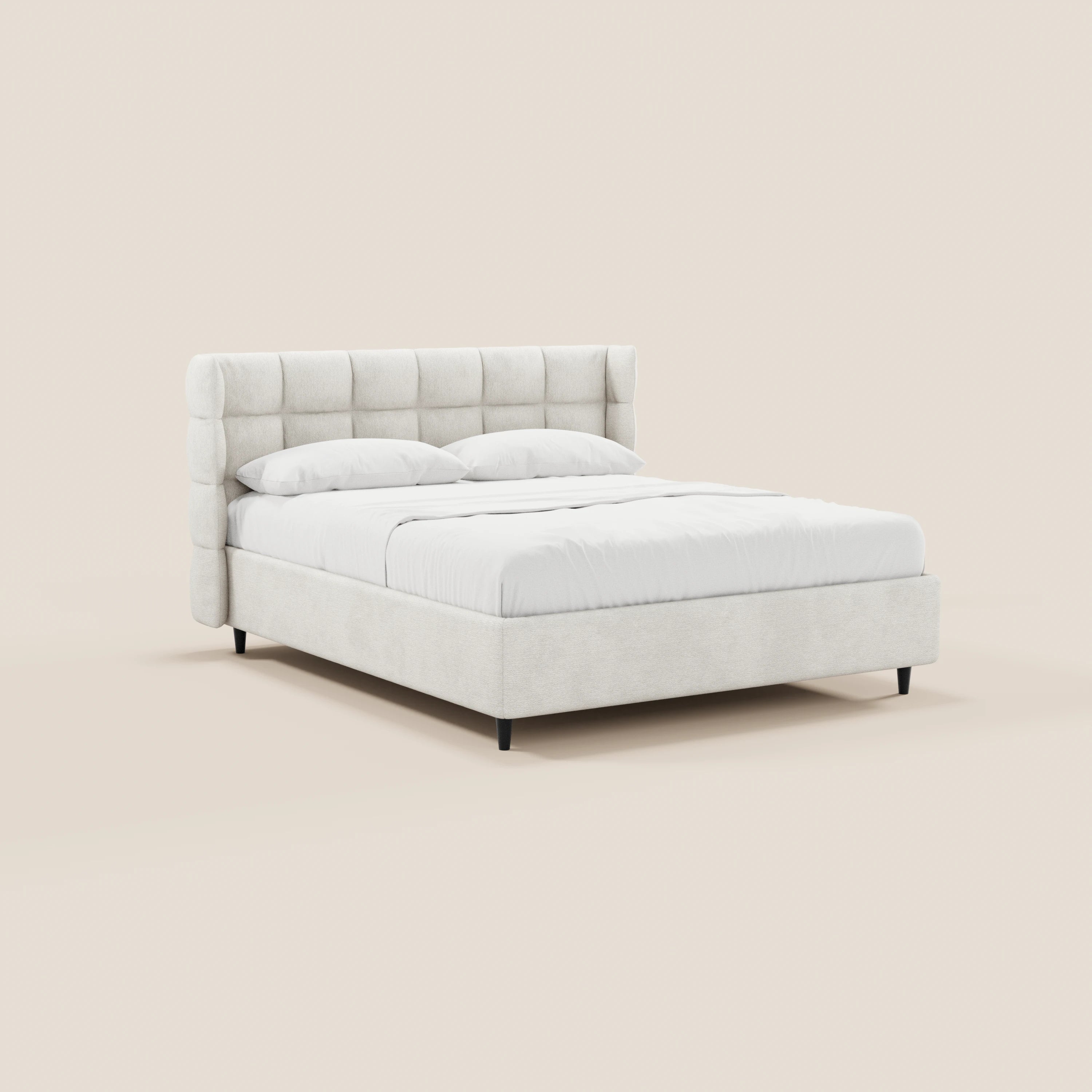 Il letto imbottito RAGNAR di Letti.store presenta una testiera avvolgente capitonné in tessuto certificato Oeko-Tex®, qui raffigurata in una tonalità neutra chiara con due cuscini bianchi su un piumone bianco.