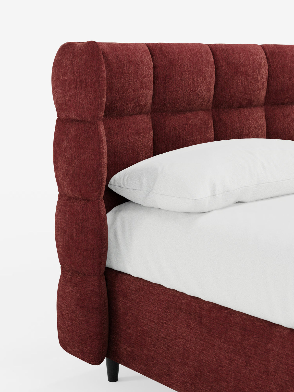 Primo piano del letto imbottito RAGNAR con contenitore e testiera capitonné avvolgente di Letti.store, rivestito con un elegante tessuto rosso intenso certificato Oeko-Tex®. La testiera presenta un raffinato motivo a griglia capitonné, che sottolinea lo stile sofisticato di questo letto contenitore. Sul letto, appoggiato su corte gambe nere, poggiano un cuscino e un materasso bianchi, che risaltano su uno sfondo bianco a tinta unita.