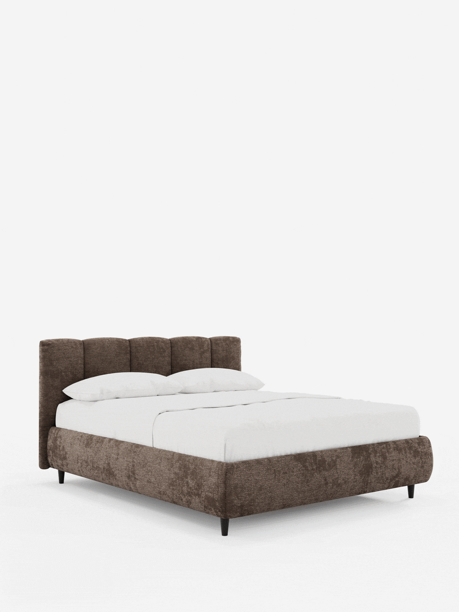 Il letto imbottito ARKAM con contenitore e testiera a cuciture verticali è un letto matrimoniale imbottito di colore marrone, caratterizzato da una testiera alta e imbottita con cuciture verticali, biancheria da letto bianca e piedi sottili di colore scuro su uno sfondo bianco a tinta unita.