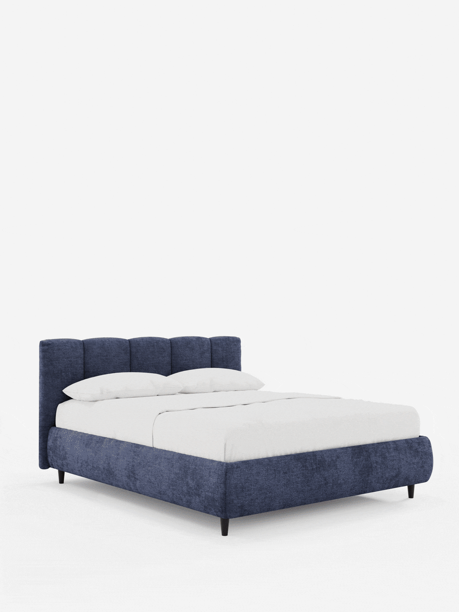 ARKAM, letto imbottito con contenitore e testiera con cuciture verticali, di colore blu navy, con biancheria da letto bianca, due cuscini e gambe corte scure su uno sfondo chiaro e semplice.