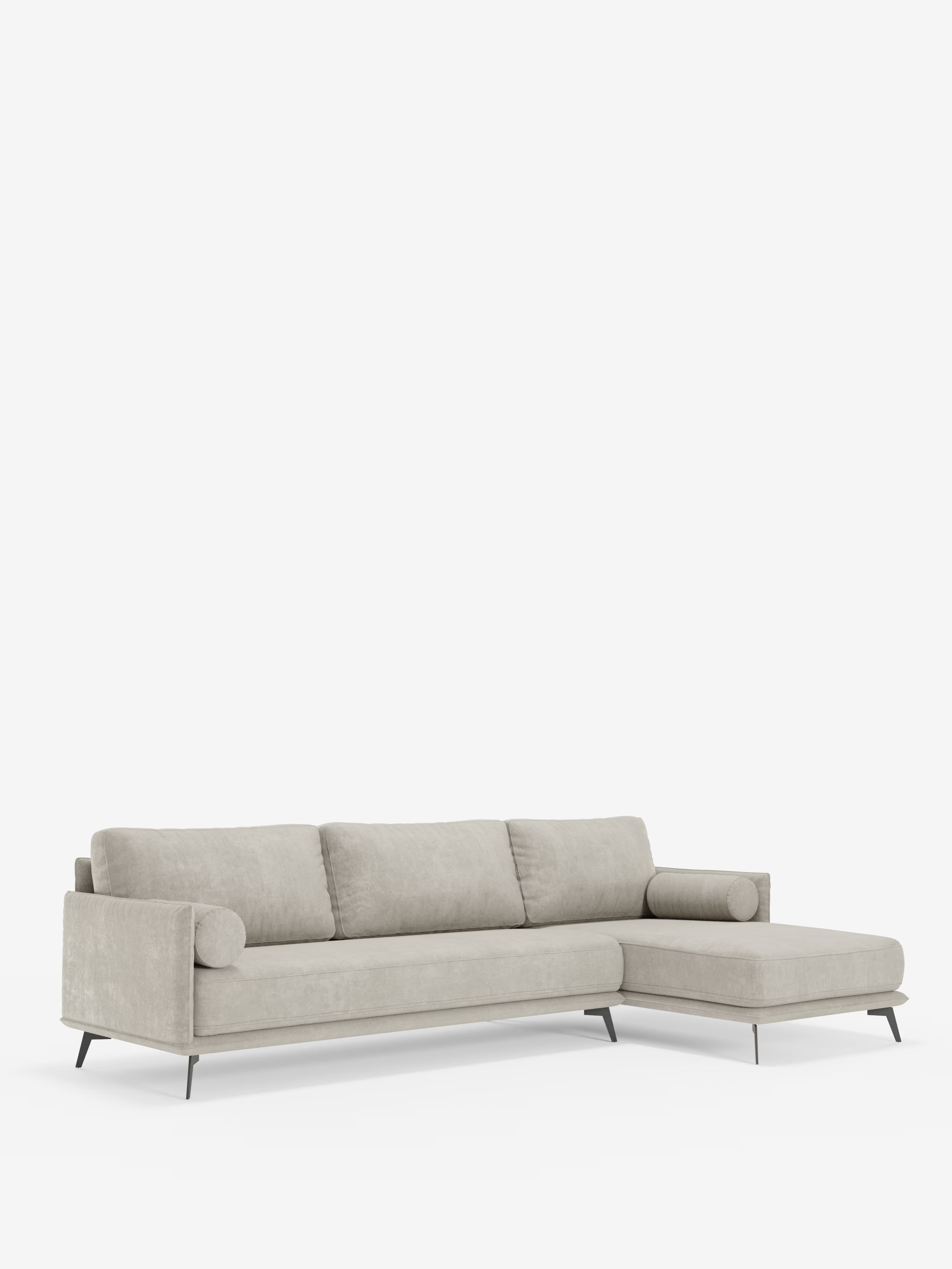 Il divano moderno angolare con penisola “Basalto” di Divani.Store è un divano componibile contemporaneo color beige chiaro, dotato di tre cuscini di seduta, tre cuscini di schienale, braccioli cilindrici ed eleganti gambe in metallo. La sua chaise longue orientata a destra e il design minimalista e moderno — che risalta su uno sfondo bianco a tinta unita — sottolineano l’eleganza raffinata di un divano di produzione italiana, rivestito in tessuto smacchiabile T31 e dotato di morbidi cuscini in piuma.