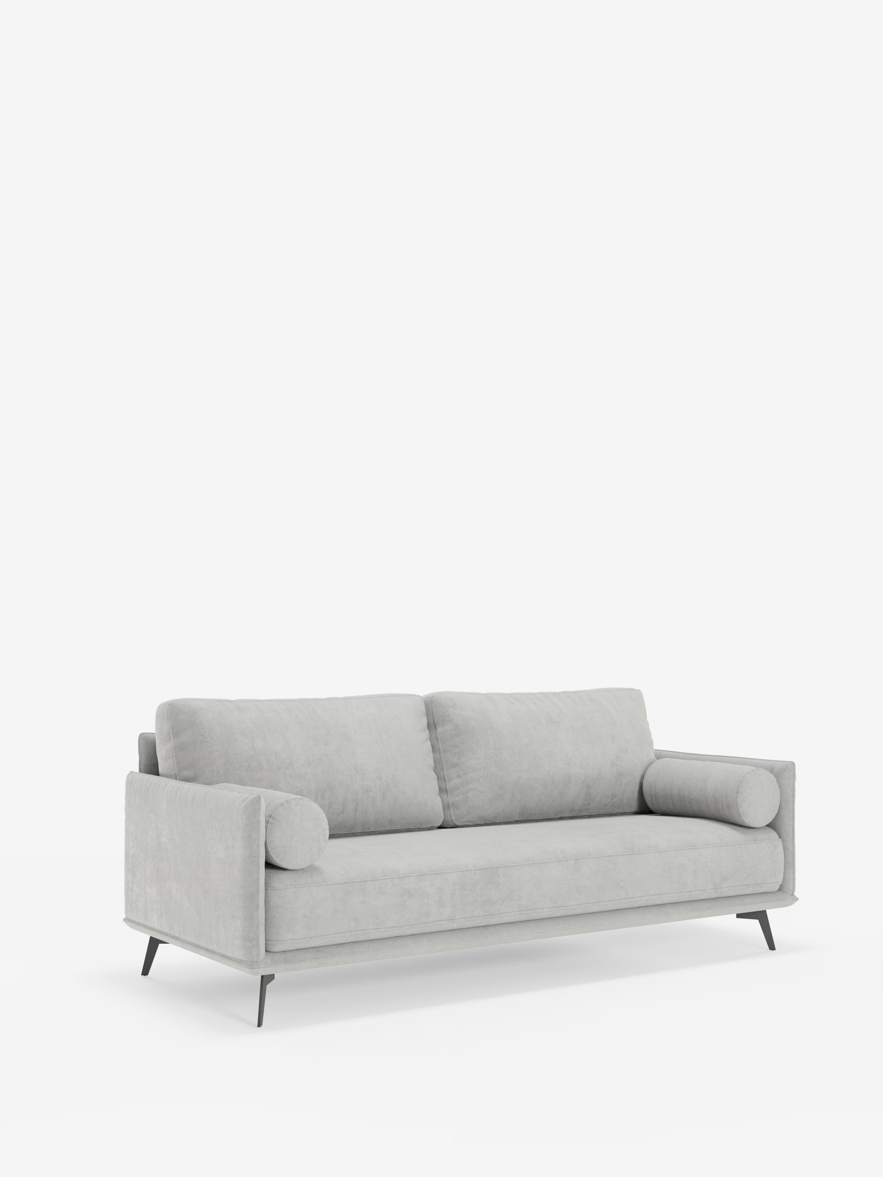 Vi presentiamo il divano lineare a 2 posti Basalto di Divani.Store: un divano moderno, di colore grigio chiaro, rivestito in tessuto smacchiabile T31. Questo elegante modello è composto da un unico cuscino di seduta, due cuscini dello schienale e due cuscini cilindrici. La sua base in metallo sottile e angolata e i braccioli dritti creano una silhouette minimalista ed elegante, che risalta magnificamente sullo sfondo bianco a tinta unita.
