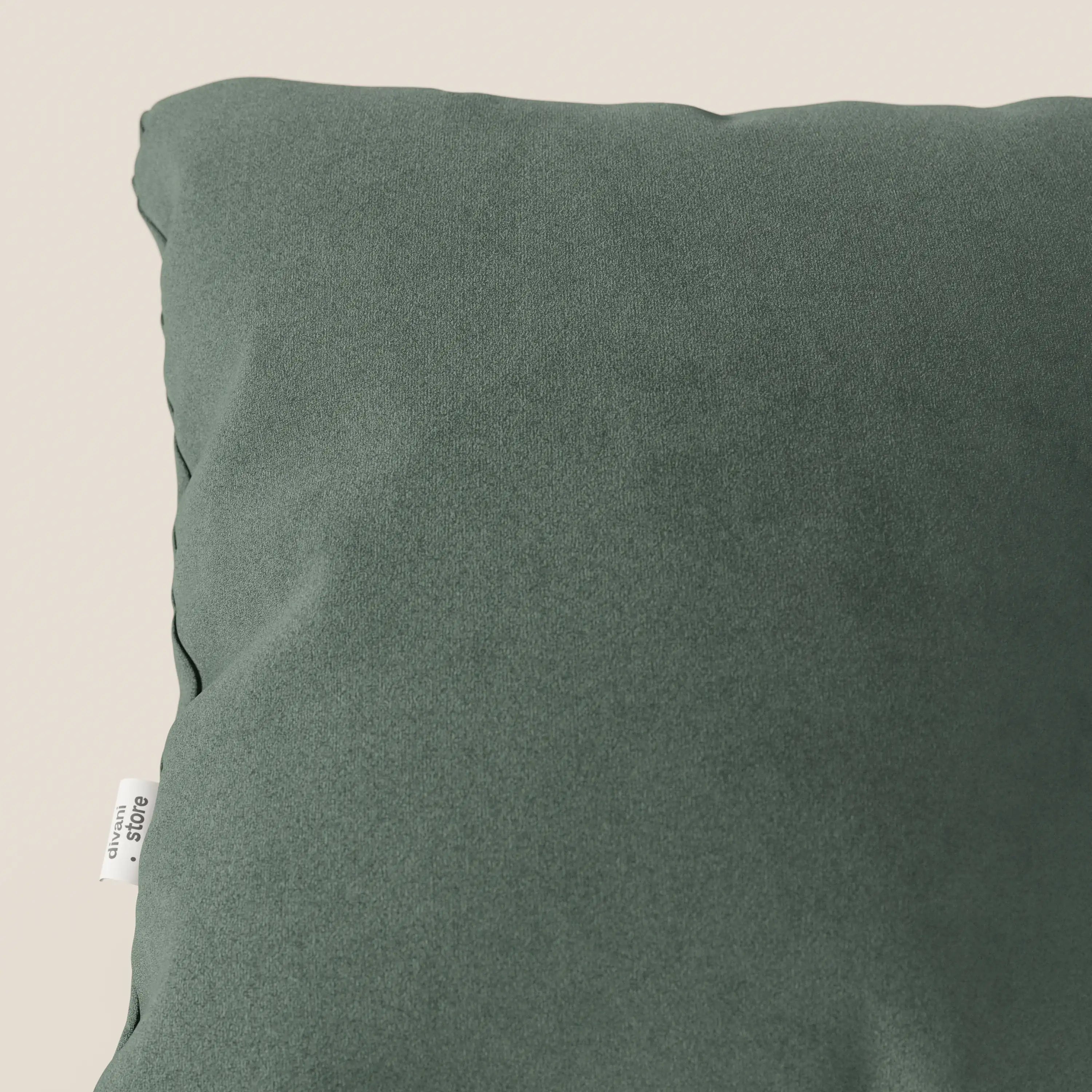 Primo piano del cuscino Jazz 45x45 di Divani.Store, in verde T11. Realizzato in smacchiabile microfibra tecnica, appare morbido e resistente ai graffi, con una targhetta bianca a sinistra e una leggera sgualcitura ai bordi su fondo chiaro.
