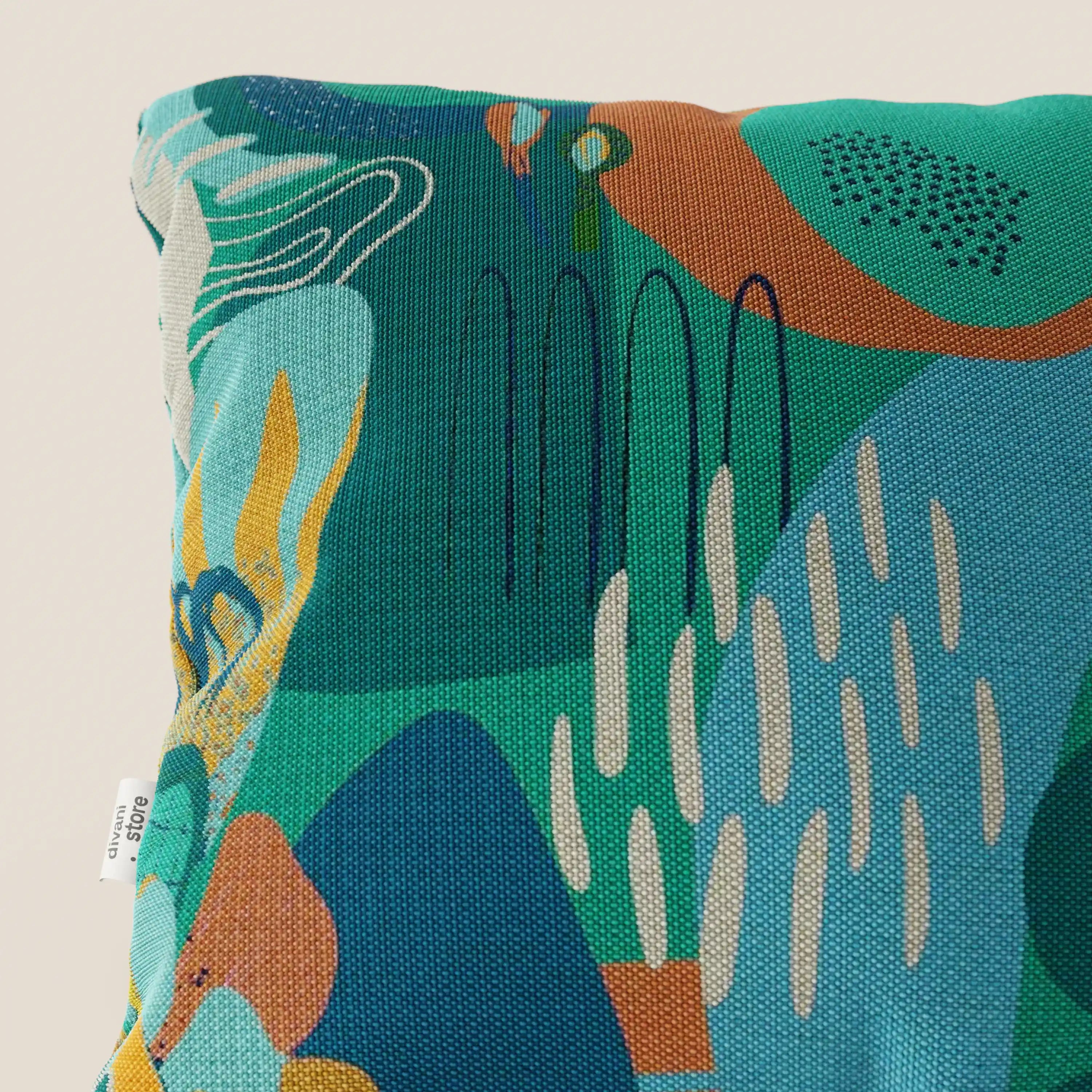 Il cuscino Joy di Divani.Store, 45x45 cm, è caratterizzato da un disegno astratto multicolore (verde, verde, marrone, giallo senape, bianco sporco) con dettagli a righe nere in fresco cotone impermeabile e ha un'etichetta bianca sulla cucitura sinistra.