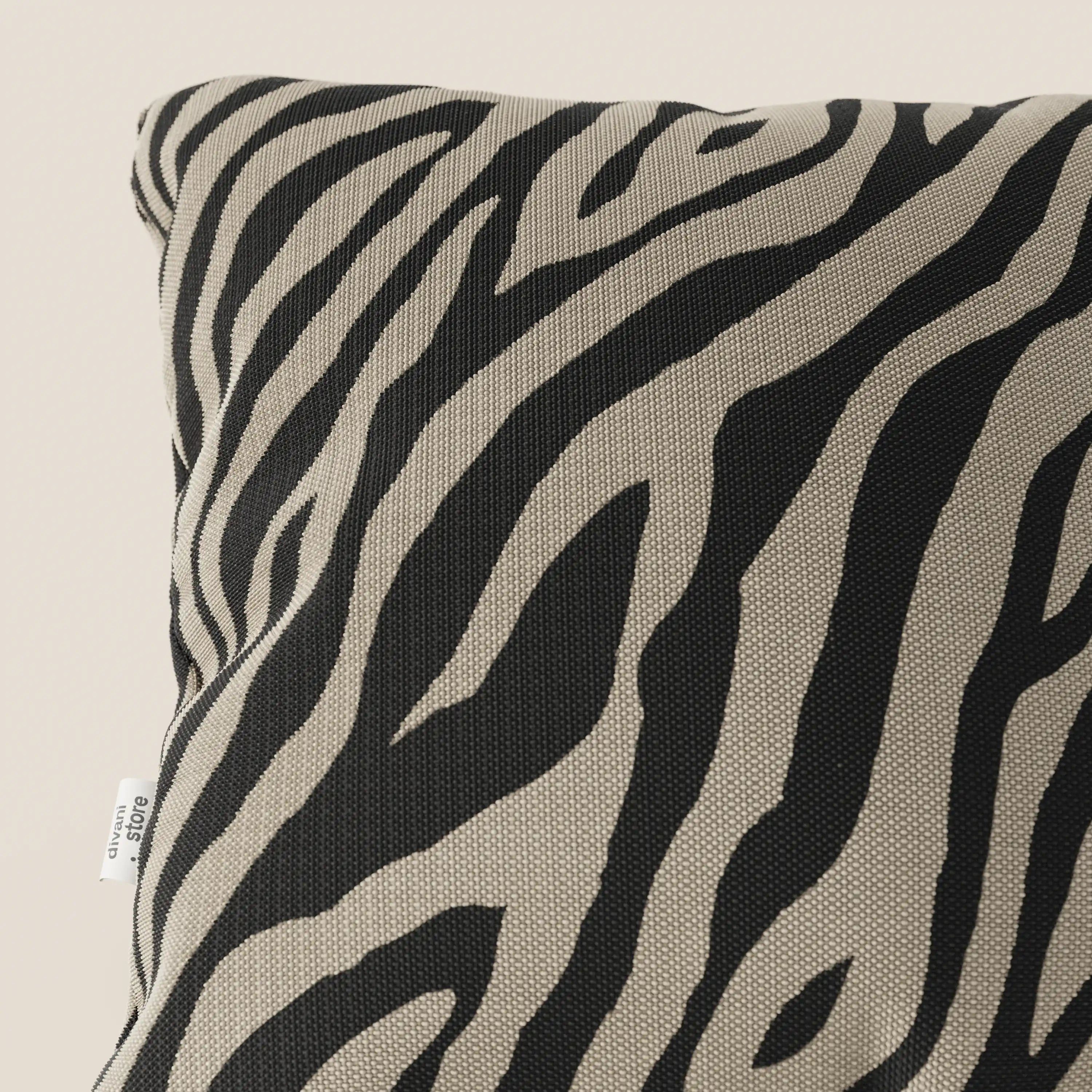 Primo piano di Stripe cuscini geometrici 45x45 di Divani.Store in tessuto idrorepellente color tortora, caratterizzato da un motivo elegante e resistente; una targhetta bianca appare sul bordo su uno sfondo neutro chiaro.