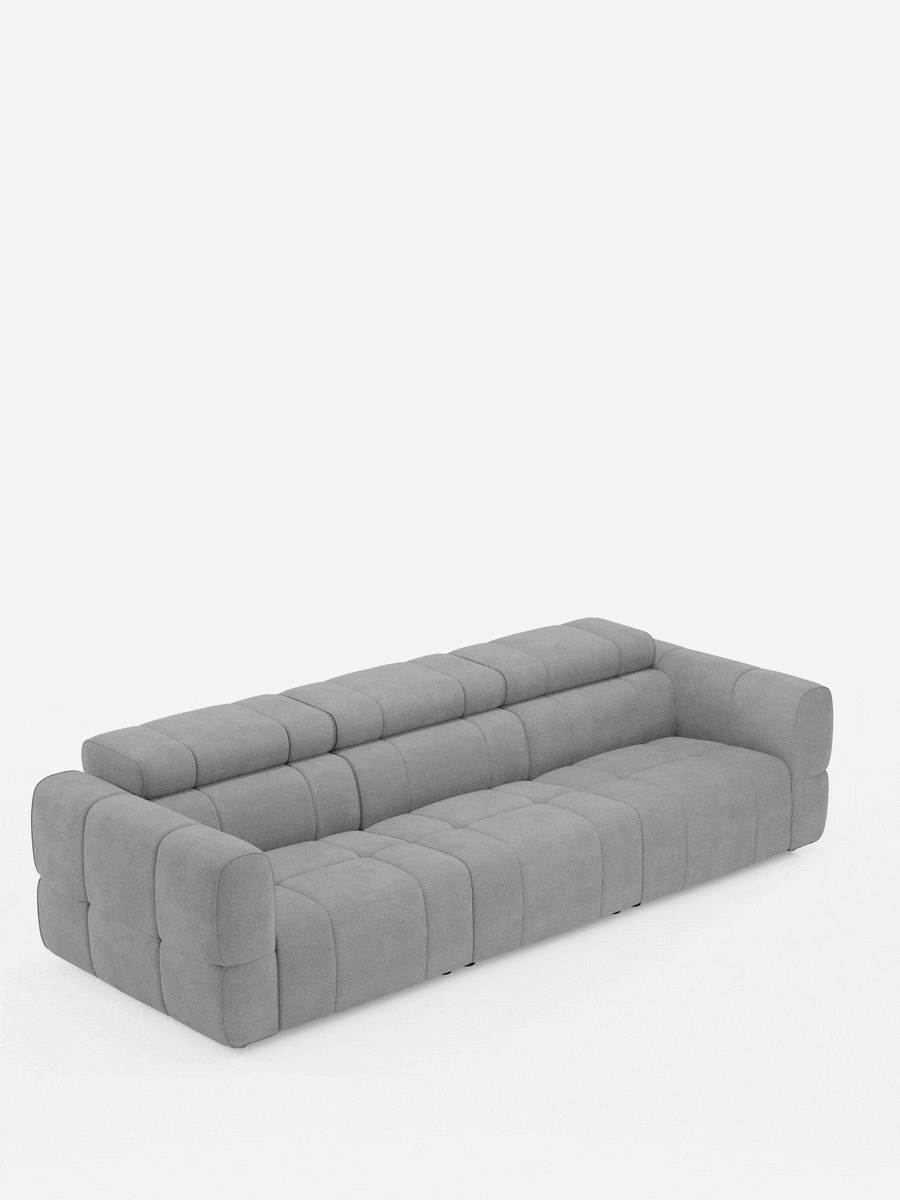 Un divano modulare Giotto grigio chiaro a 4 posti con poggiatesta reclinabili e funzione relax elettrica opzionale, rivestito in tessuto smacchiabile T23, caratterizzato da un design rettangolare trapuntato con braccioli bassi, uno schienale unico e una morbida finitura in tessuto.