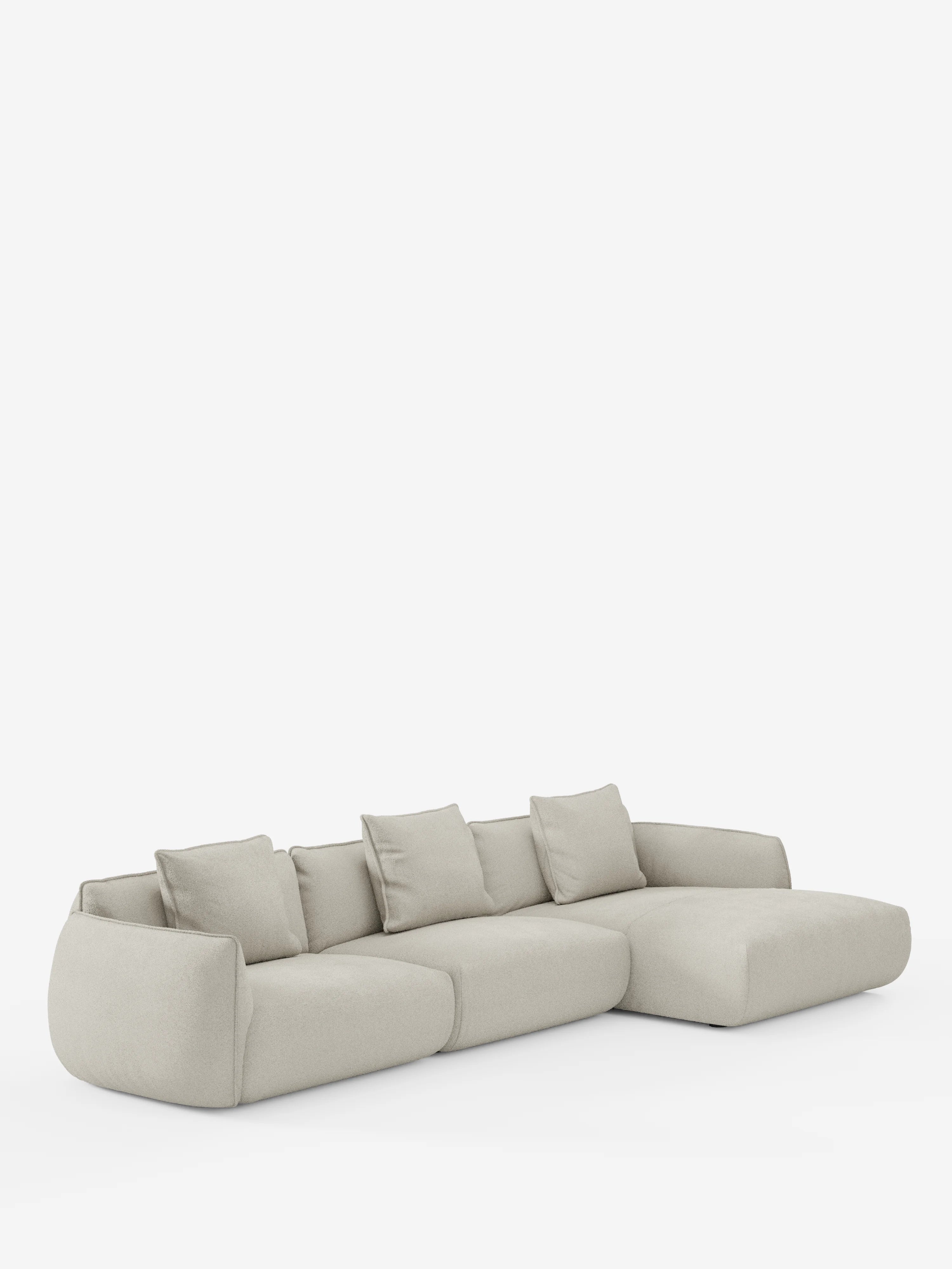 Il divano angolare con penisola componibile Nimbus in morbido tessuto effetto cotone smacchiabile T33 di Divani.Store è un divano componibile moderno, di colore grigio chiaro, caratterizzato da un profilo basso, ampi braccioli e cinque cuscini dello schienale sfoderabili. Include una chaise longue sul lato destro ed è esposto su uno sfondo bianco a tinta unita.