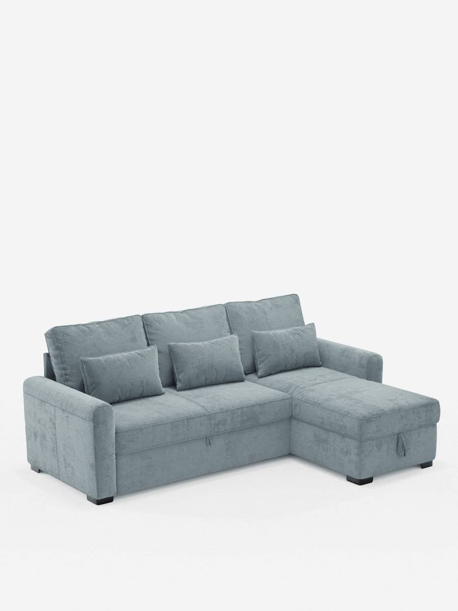 Ottaviano, divano letto con letto estraibile - penisola reversibile e contenitore in tessuto materico lavabile: un divano letto angolare azzurro con chaise longue a destra, tre cuscini dello schienale, tre cuscini decorativi, maniglia del contenitore e piedini scuri.