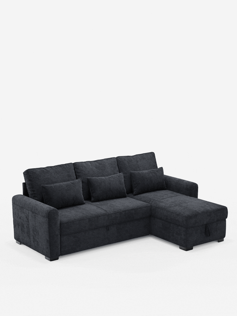 Un divano letto Ottaviano con letto estraibile - penisola reversibile e contenitore in tessuto materico smacchiabile grigio antracite, composto da chaise longue, tre cuscini dello schienale e tre cuscini decorativi su uno sfondo grigio chiaro.