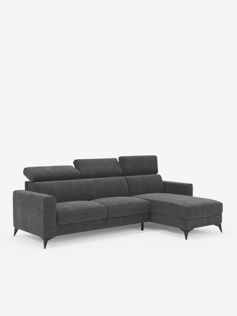 Il divano letto angolare Pegaso di Divani.Store è un moderno divano componibile grigio scuro composto da tre posti con schienali imbottiti, una chaise longue sul lato destro e poggiatesta regolabili. Realizzato in tessuto jacquard T22 smacchiabile, il suo design si caratterizza per linee pulite, sottili gambe nere e uno stile minimalista. Questo elegante divano offre anche una pratica penisola contenitore per riporre comodamente gli oggetti. Presenta su uno sfondo bianco a tinta unita.