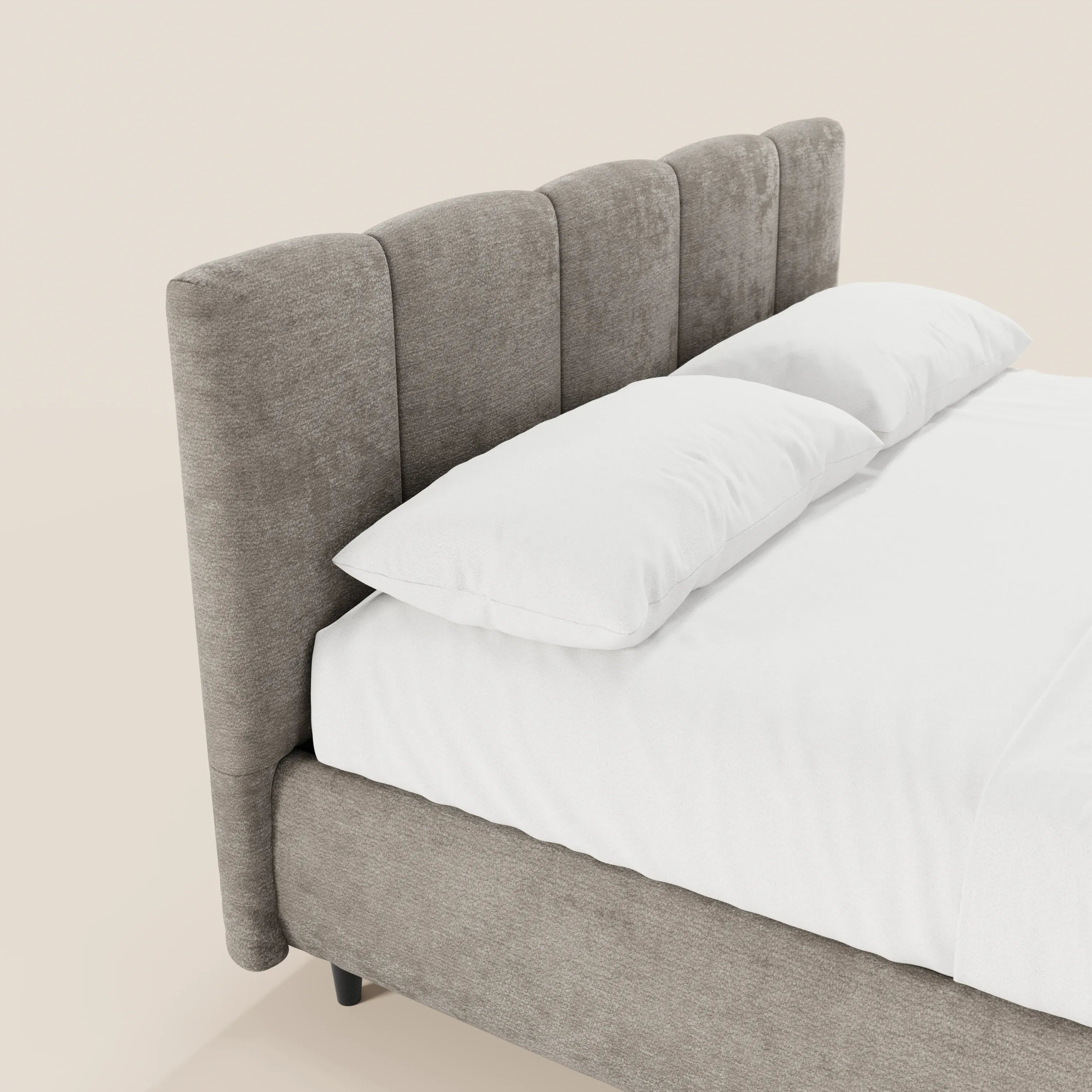 Il letto imbottito ARKAM di Letti.store presenta una testiera con lavorazione verticale e un vano contenitore, in stile shabby chic, realizzato in tessuto certificato Oeko-Tex®, messo in risalto dalla biancheria bianca su uno sfondo chiaro.