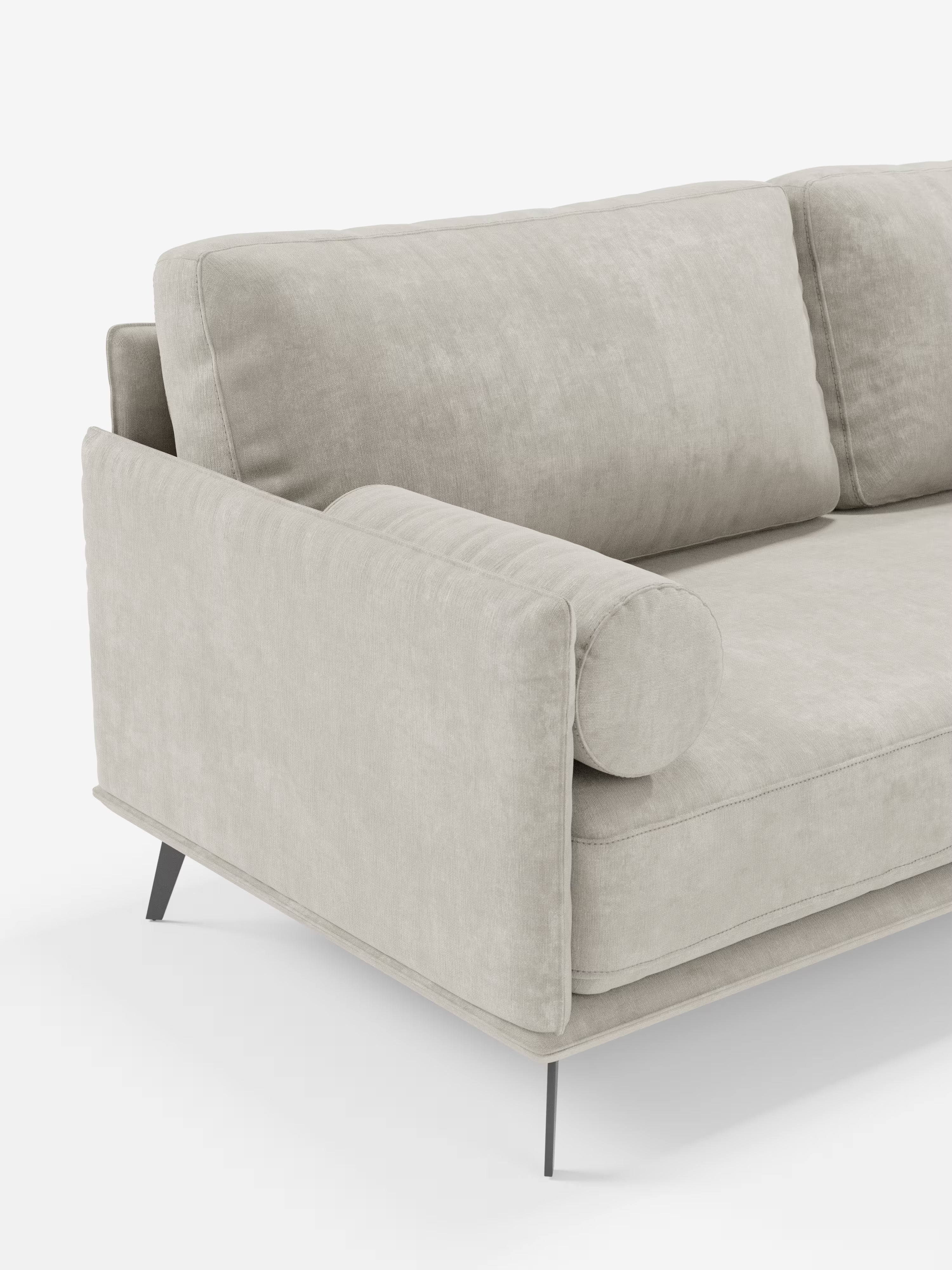 Vi presentiamo il divano moderno angolare con penisola Basalto di Divani.Store: un divano italiano elegante e minimalista dal design modulare. Rivestito in tessuto T31 beige chiaro e resistente alle macchie, è dotato di morbidi cuscini in piuma, un cuscino cilindrico sul bracciolo e sottili gambe in metallo nero. Il rivestimento dalla morbida trama e le linee pulite mettono in risalto una lavorazione artigianale sofisticata: solo una parte di questo raffinato divano è visibile sullo sfondo bianco.
