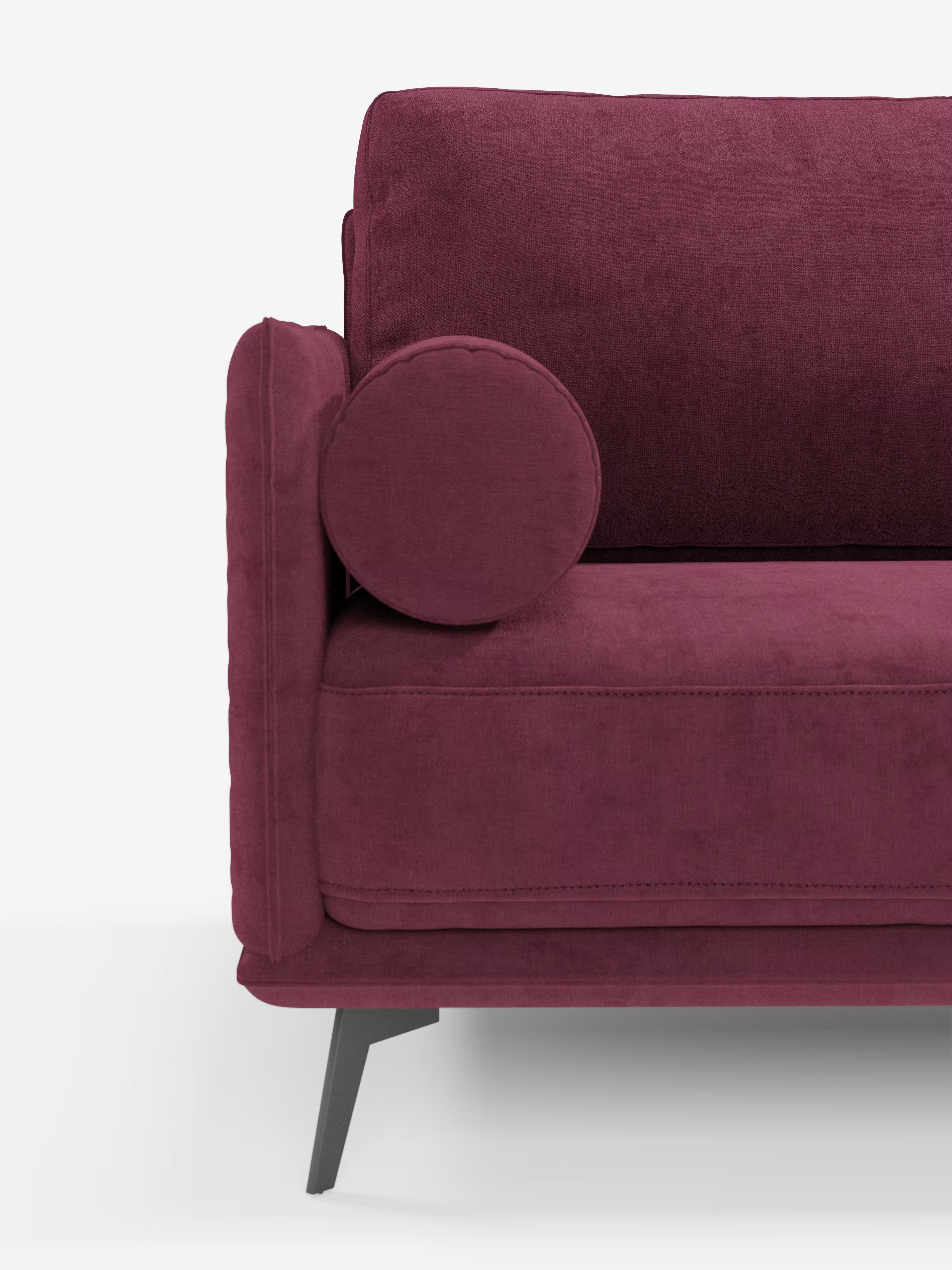L'immagine mostra il lato destro del divano Basalto, modello lineare a 2 o 3 posti con seduta unica e base in metallo, rivestito in tessuto smacchiabile T31 di Divani.Store, in un tessuto color bordeaux intenso. Un cuscino rotondo poggia su questo design dalle linee pulite, caratterizzato da gambe corte e angolate di colore scuro e da un’estetica moderna e minimalista. L’immagine mette in risalto solo una parte dello schienale, della seduta e del bracciolo su uno sfondo bianco a tinta unita.