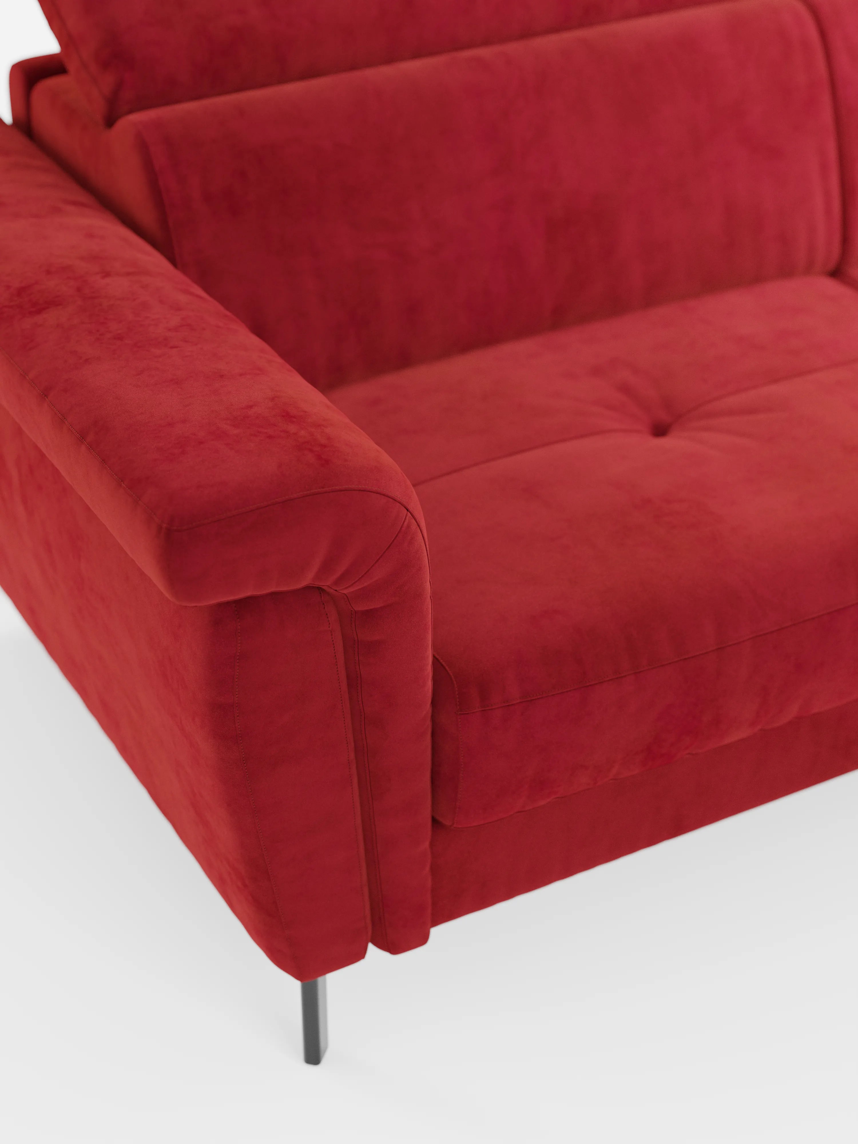 Un primo piano del divano letto di design Capri con piedini alti di Divani.Store, caratterizzato da un raffinato rivestimento smacchiabile T30 effetto velluto, poggiatesta regolabili, braccioli angolati, due cuscini di seduta trapuntati e sottili gambe in metallo nero su sfondo bianco, che mette in risalto la squisita manifattura italiana.