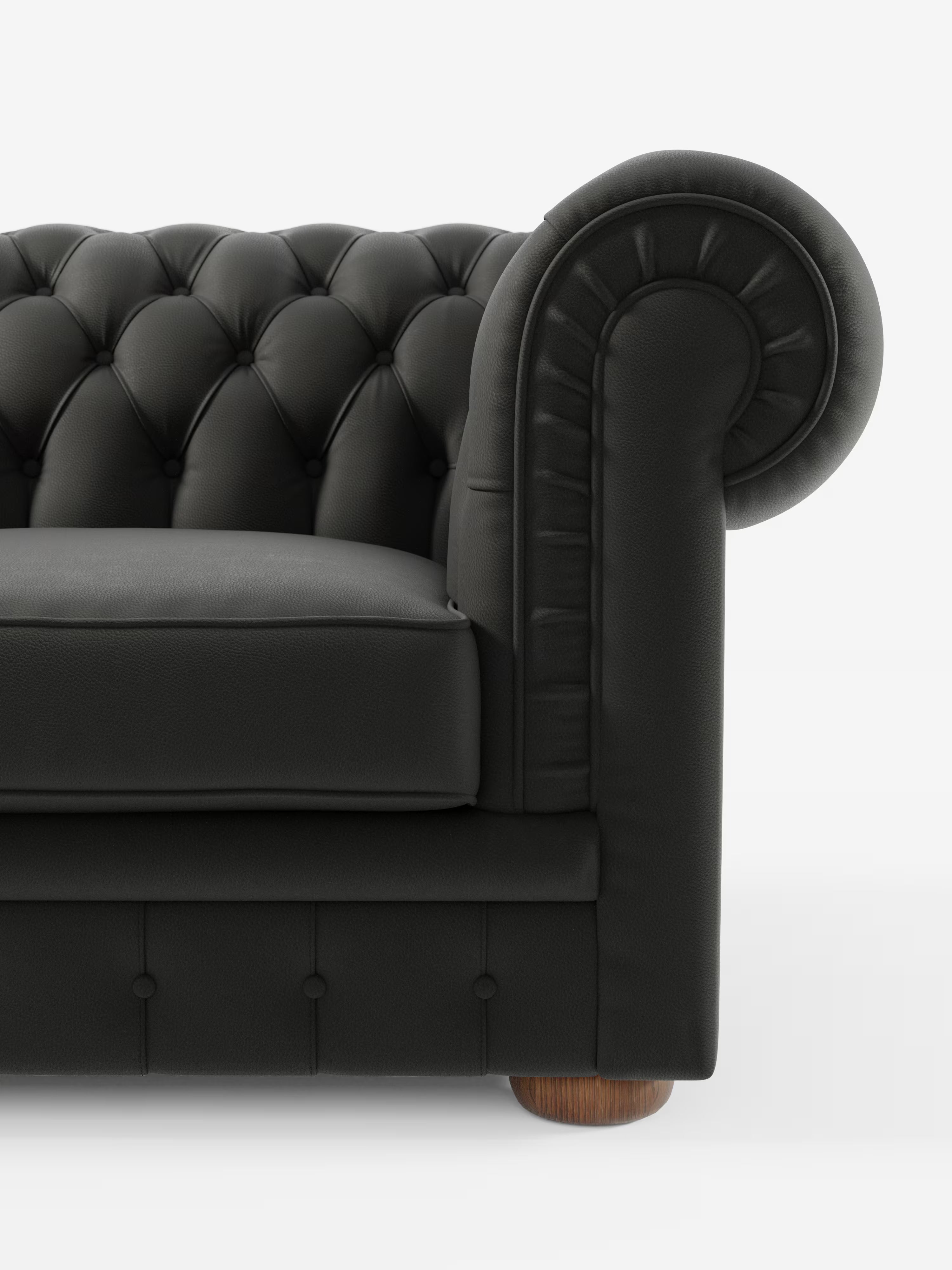 Primo piano del modello Chester – Divano Chesterfield in vera pelle spessorata a 2 e 3 posti di Divani.Store, che mette in risalto il rivestimento in vera pelle nera, lo schienale trapuntato, i braccioli arrotondati con dettagli plissettati, il cuscino di seduta spesso, i bottoni decorativi e le gambe rotonde in legno, il tutto su uno sfondo bianco a tinta unita.