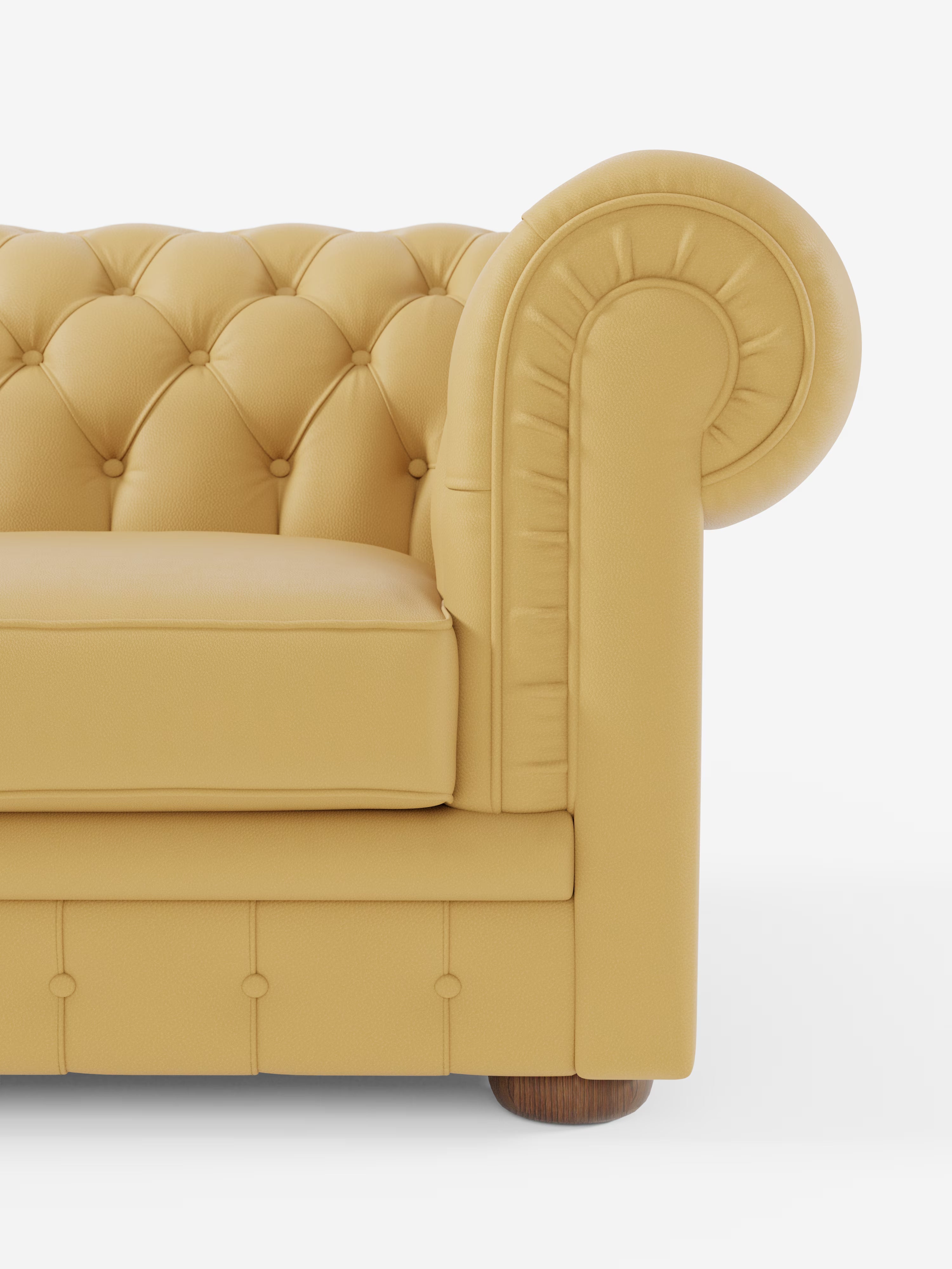 Primo piano di un divano Chester 4 Posti 3 sedute in vera pelle, color giallo senape – Chesterfield Capitonné Artigianale di Divani.Store. Sono visibili solo il bracciolo sinistro, il cuscino e parte dello schienale. Il bracciolo arrotondato presenta i classici dettagli a bottoni, segno distintivo della lavorazione artigianale. Il divano poggia su una gamba corta e rotonda in legno su uno sfondo bianco.