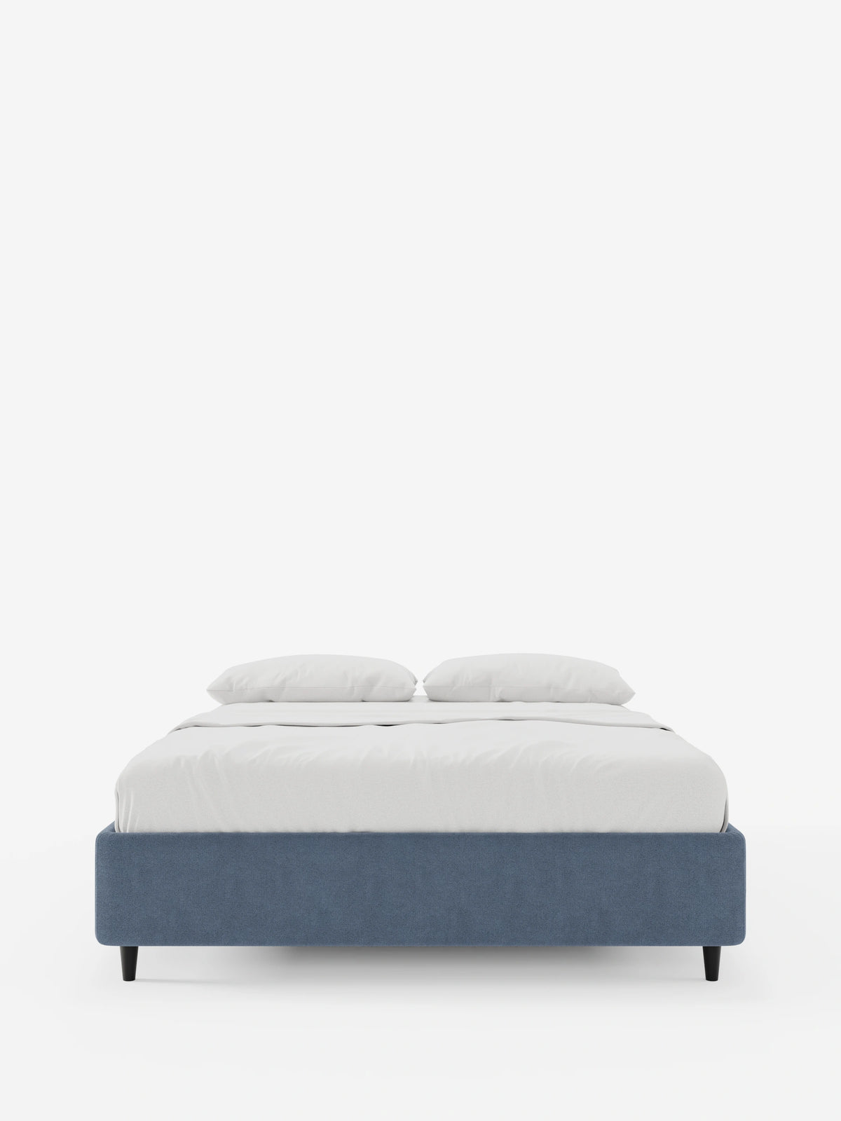ERON: letto a doghe imbottito con contenitore in tessuto impermeabile certificato Oeko-Tex, un letto imbottito dal profilo basso con base blu, gambe affusolate scure e biancheria da letto candida con due cuscini coordinati su uno sfondo bianco a tinta unita.