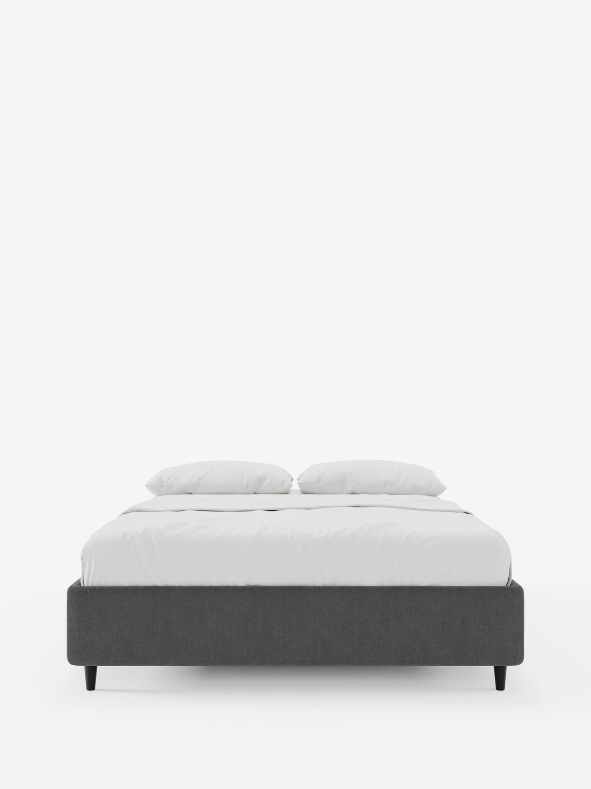 Il letto sommier imbottito ERON con contenitore, rivestito in tessuto impermeabile certificato Oeko-Tex, spicca su uno sfondo bianco, caratterizzato da una struttura imbottita grigio scuro, gambe corte nere e biancheria da letto candida con due cuscini.