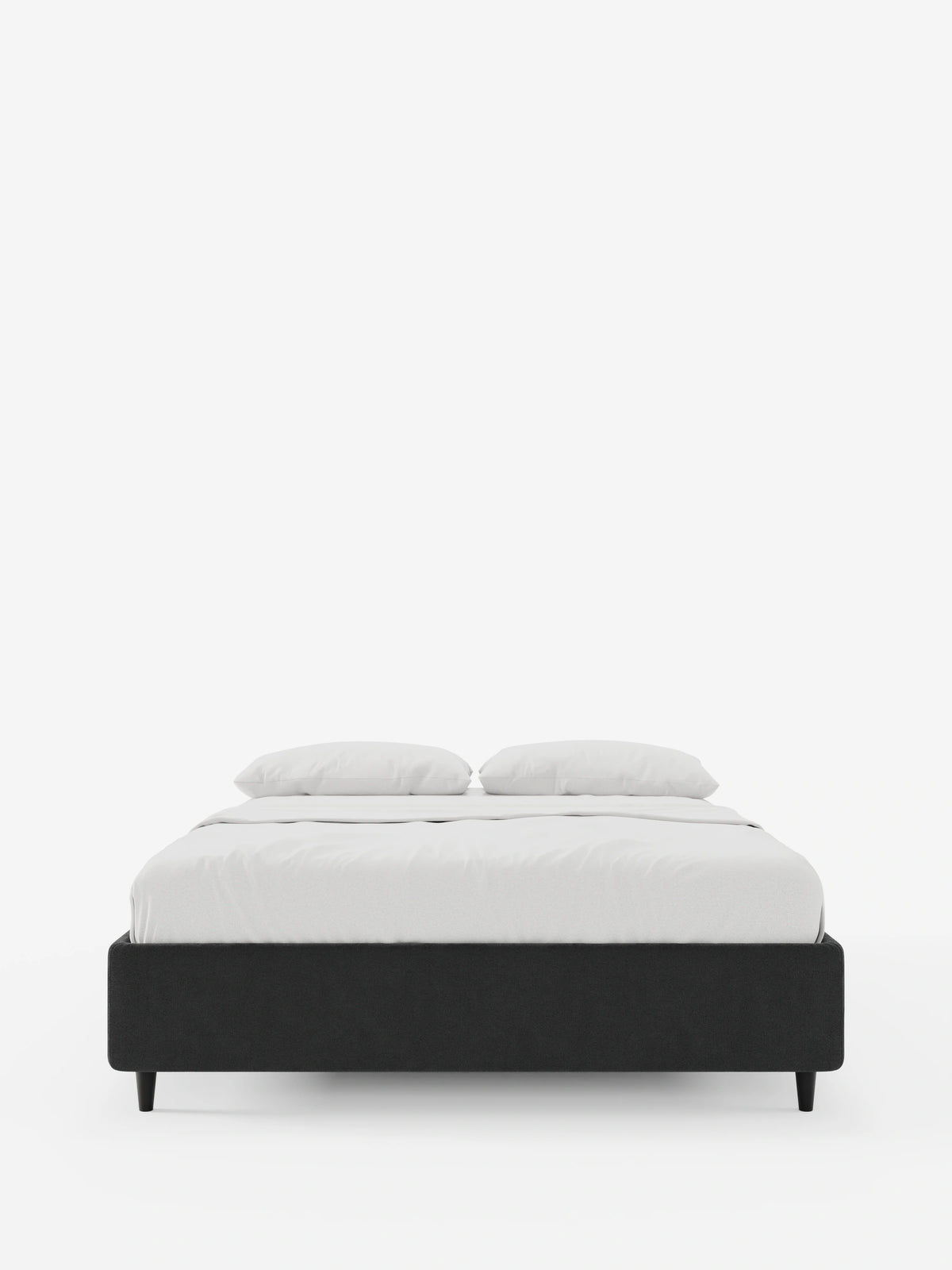 Il letto sommier imbottito ERON con contenitore in tessuto impermeabile certificato Oeko-Tex di Letti.store presenta una struttura rivestita in grigio scuro, una base dal profilo ribassato con gambe affusolate ed è abbinato a biancheria da letto di un bianco brillante e a due cuscini.