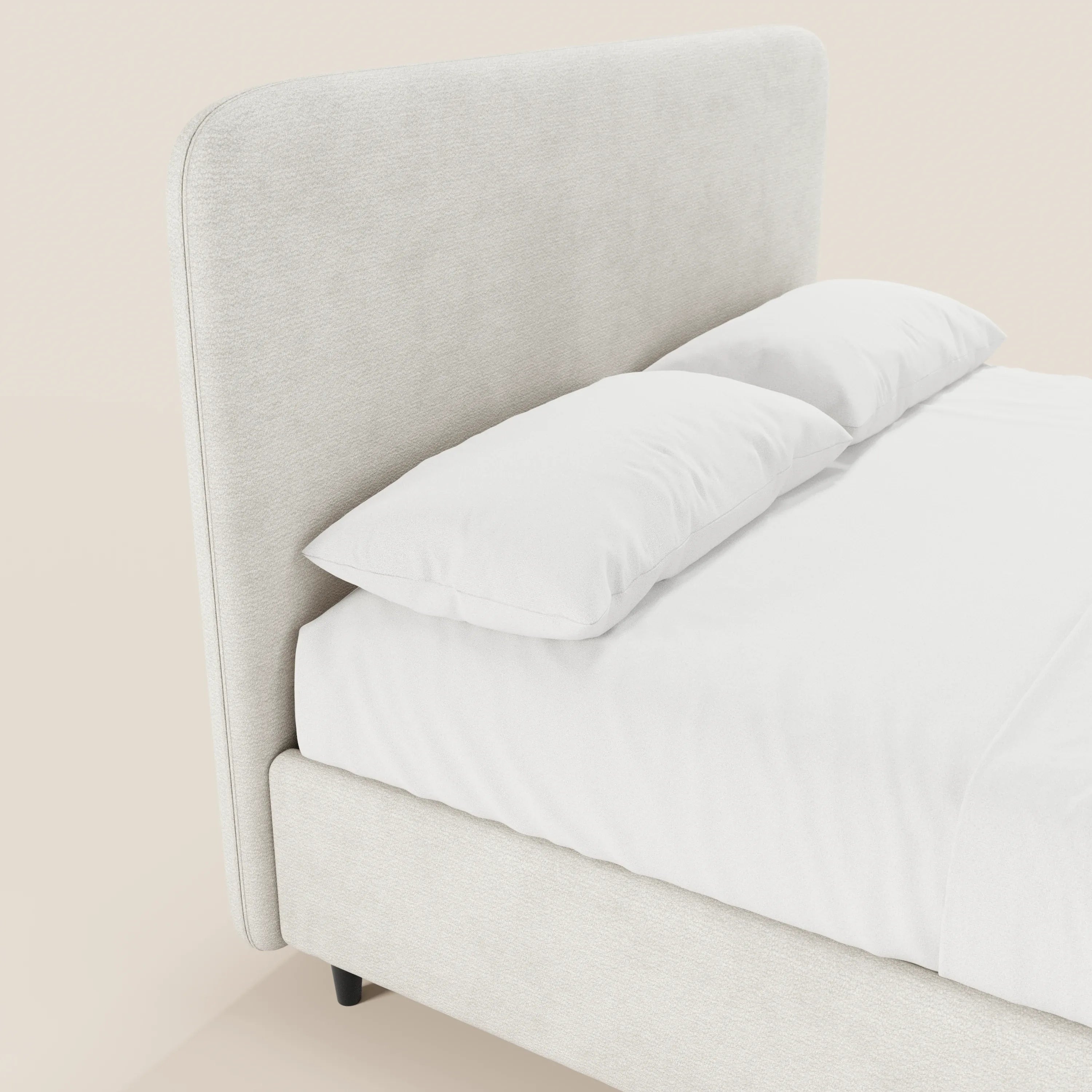 Primo piano del letto imbottito KAELOS Letto Minimal di Letti.store, caratterizzato da una testiera e da una struttura rivestite in ciniglia beige chiaro con bordi arrotondati, gambe alte, base contenitiva, lenzuolo con angoli bianco e due cuscini bianchi su uno sfondo a tinta unita.