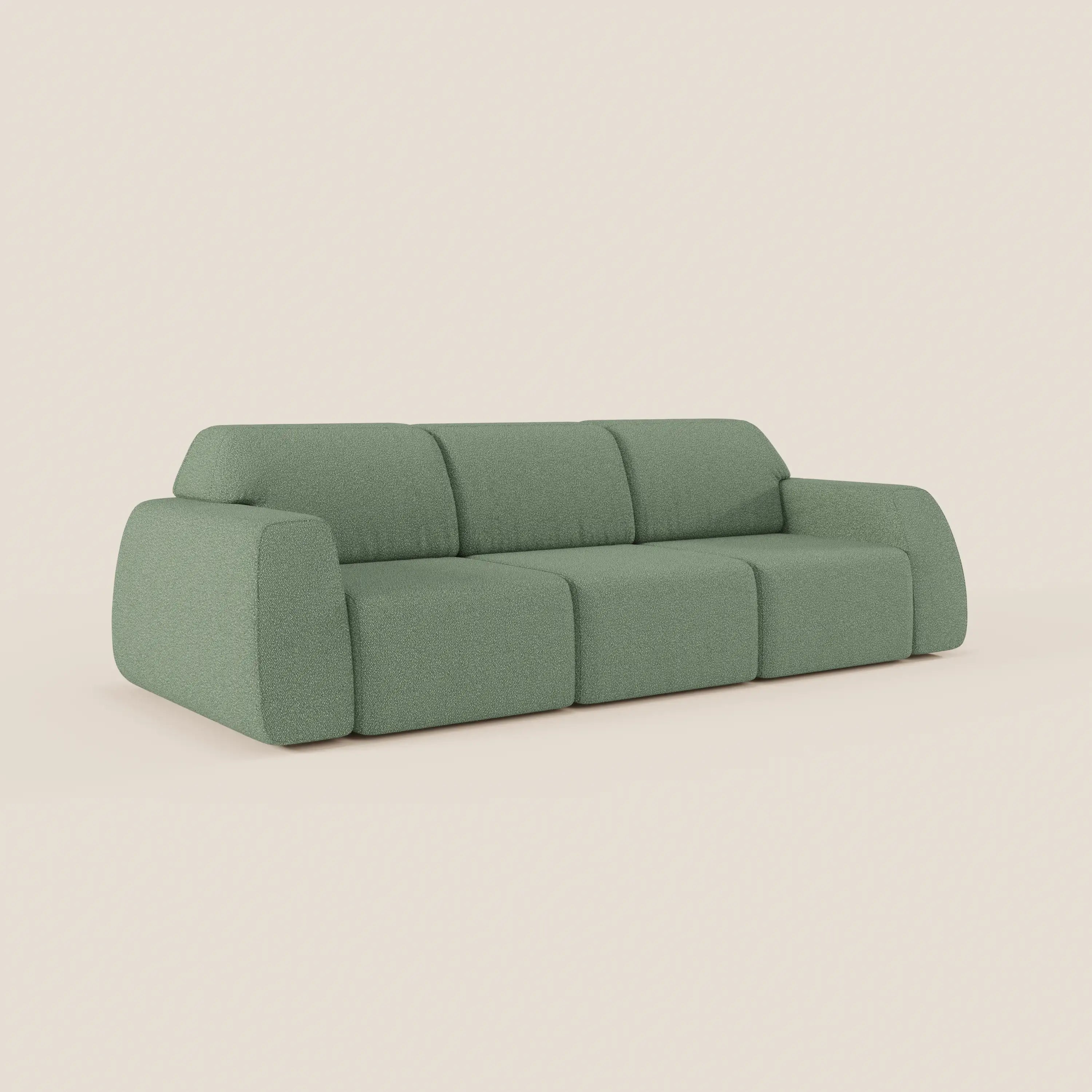 Il divano Orbit di Divani.Store è caratterizzato da 3 sedute scorrevoli e allungabili, tessuto sfoderabile T33 antimacchia effetto cotone in colore verde tenue, ampi braccioli arrotondati, schienale basso e un design deciso su sfondo beige chiaro.
