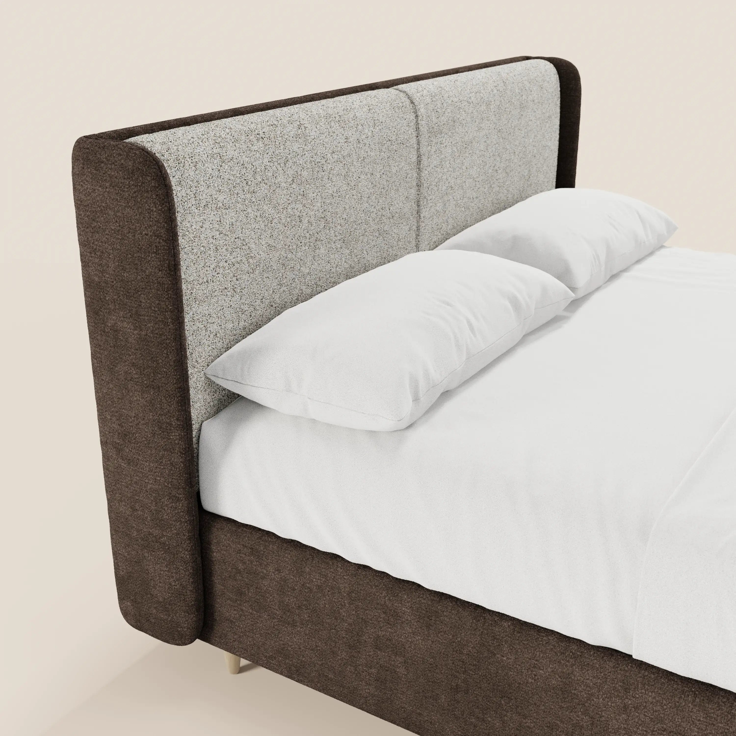 Il letto imbottito bicolore VALKIRIA di Letti.store si distingue per i cuscini dello schienale e la testiera curva avvolgente. Il vano contenitore e il raffinato design italiano risaltano sullo sfondo beige, con biancheria candida e linee moderne.