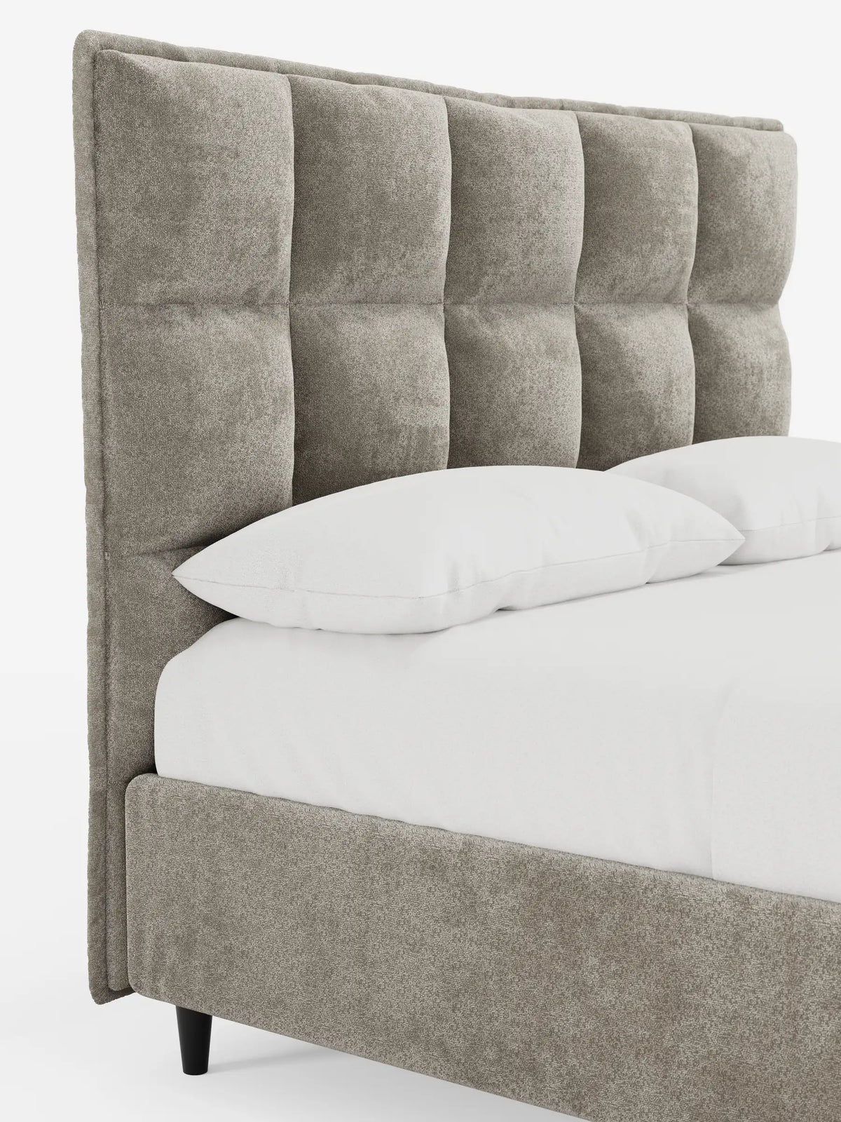 Vista laterale di un letto imbottito AURO con contenitore e testiera alta capitonné in ciniglia Oeko-Tex®, con testiera alta capitonné grigia, struttura imbottita, due cuscini bianchi e lenzuola bianchissime.