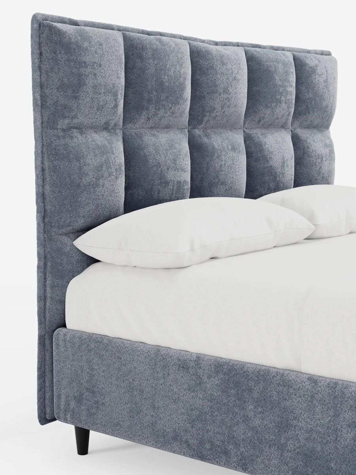 Una vista laterale di un letto imbottito AURO con contenitore e testiera capitonné alta in ciniglia Oeko-Tex® grigia, caratterizzato da una testiera alta capitonné, biancheria da letto bianca e gambe cilindriche scure su sfondo bianco.