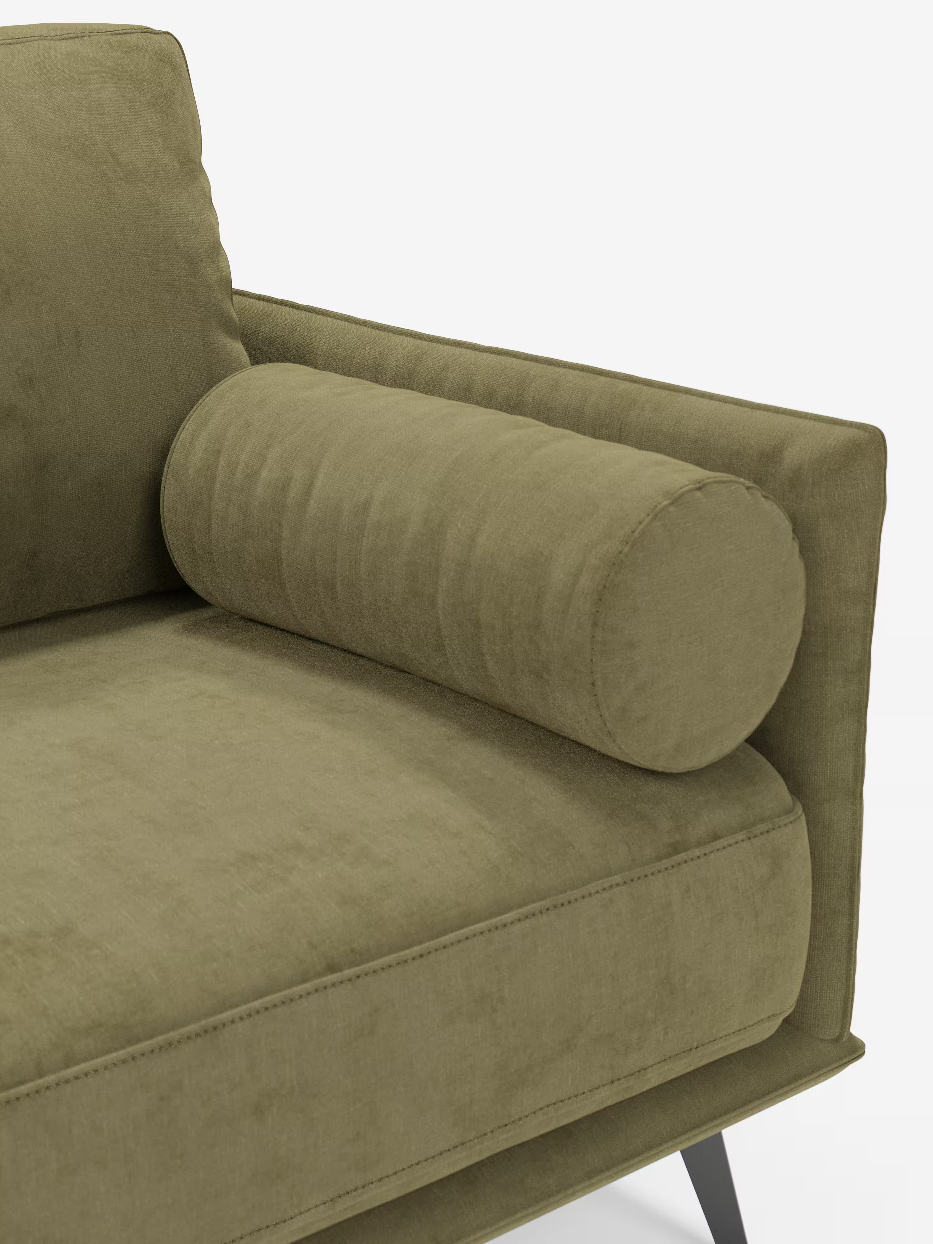 Un primo piano del moderno divano lineare a 2 posti Basalto, color verde oliva, di Divani.Store, caratterizzato da un morbido cuscino cilindrico appoggiato al bracciolo e al cuscino di seduta. Il rivestimento sfoderabile in tessuto smacchiabile T31 unisce comfort e facilità di manutenzione, mentre la base in metallo nero, slanciata e angolare, sottolinea l’estetica minimalista del divano. Lo sfondo è bianco a tinta unita.