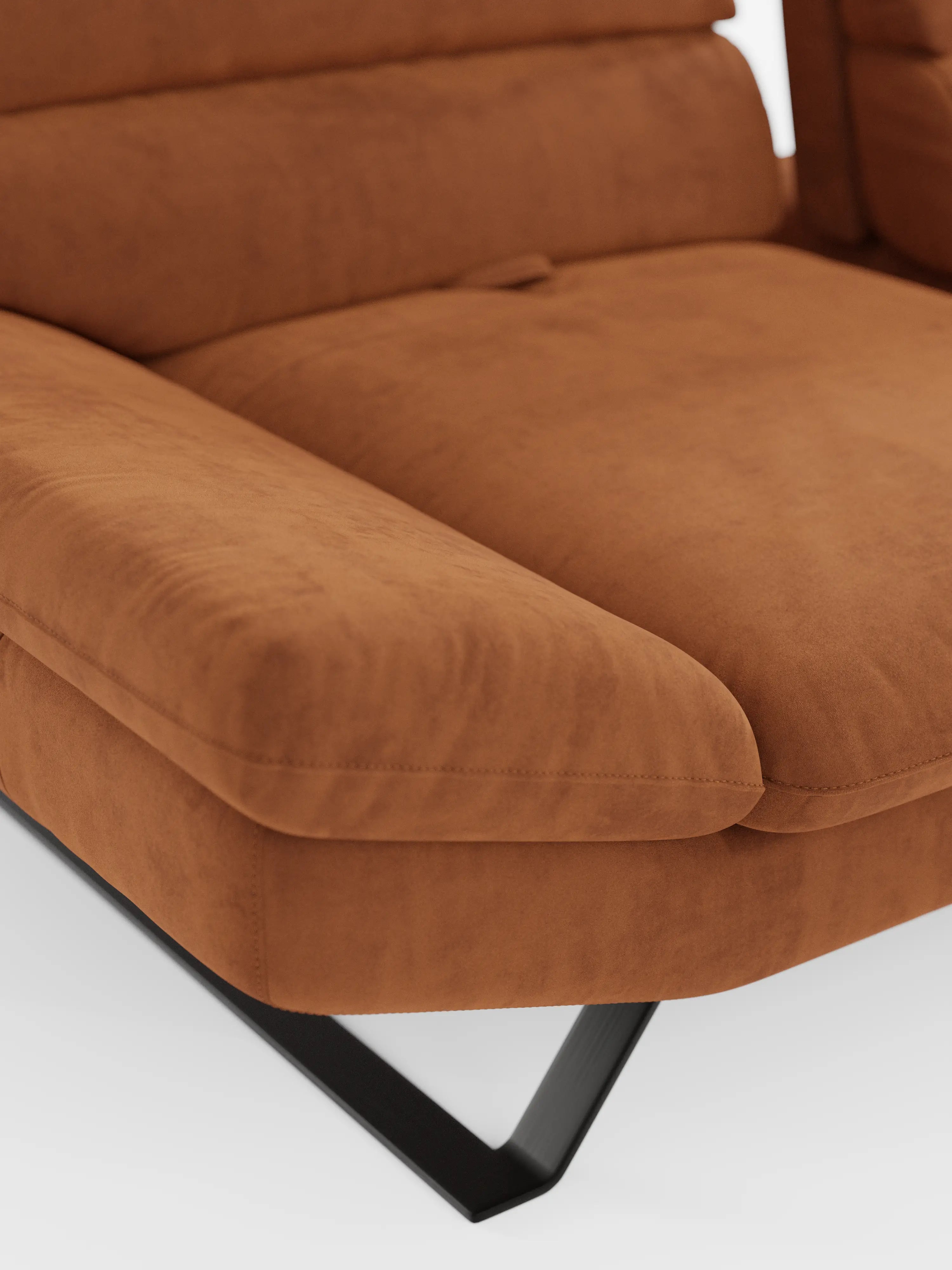 Primo piano del divano angolare con penisola e schienali traslanti Eclipse di Divani.Store, caratterizzato da un morbido rivestimento in microfibra tecnica T11 di colore marrone ruggine, facile da pulire, ampi braccioli imbottiti e una gamba inclinata in metallo nero su sfondo bianco. Il tessuto liscio e soffice ne esalta il comfort e il design contemporaneo.