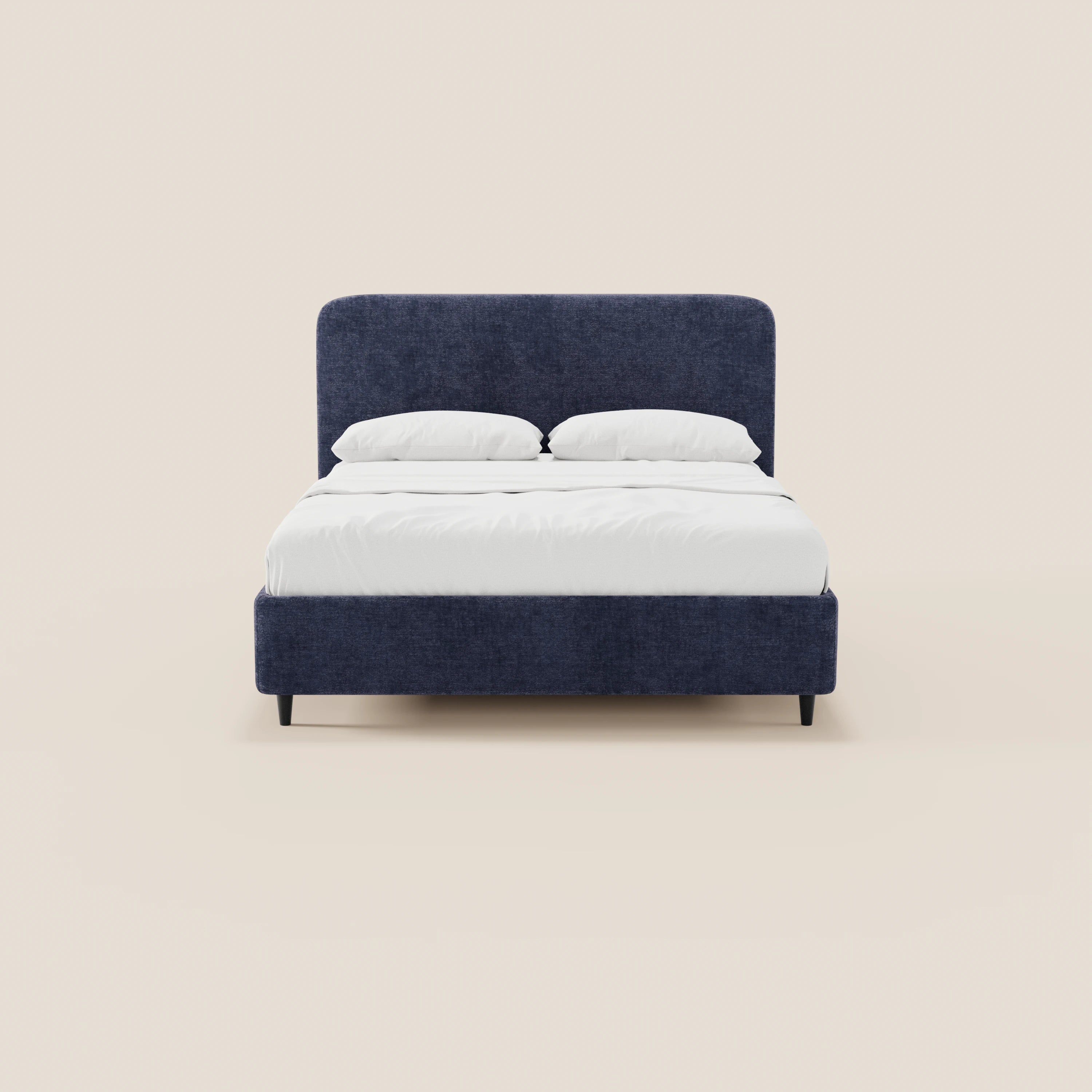 Il letto imbottito ONYX di Letti.store, in blu navy con gambe nere, biancheria da letto bianca e due cuscini bianchi, presenta un’alta testiera verticale rettangolare in tessuto certificato Oeko-Tex®, raffigurata su uno sfondo beige chiaro a tinta unita.