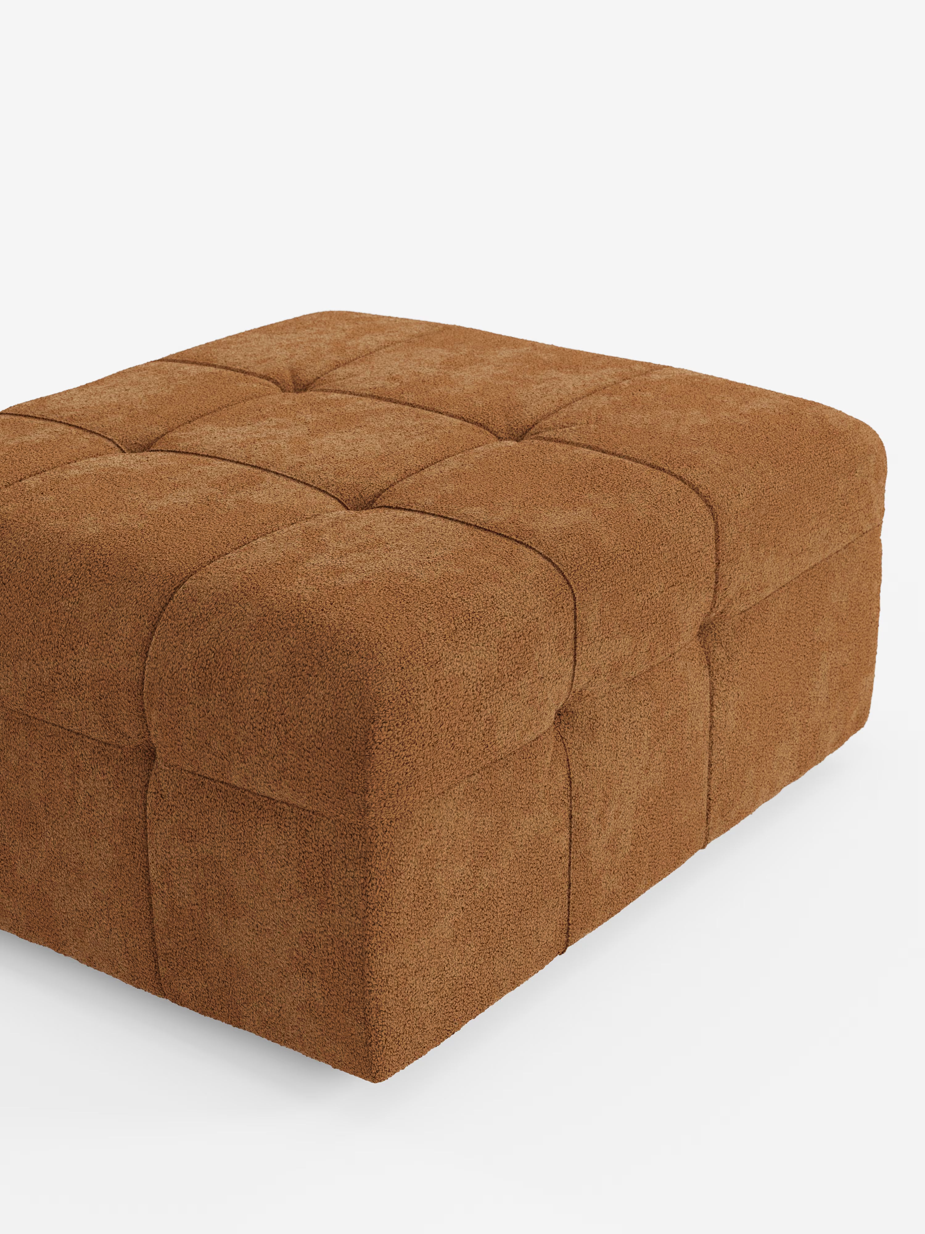 Un pouf e modulo Mosaic di Divani.Store, spazioso e di forma quadrata, che misura 96x77 cm, è rivestito in morbido tessuto bouclé T21 resistente alle macchie e dalla trama rigata. La sua superficie presenta quadrati arrotondati e generosamente imbottiti, con cuciture discrete e la classica trapuntatura capitonné con bottoni, per un look moderno ispirato al mosaico. Adagiato su uno sfondo bianco liscio, senza gambe a vista né dettagli aggiuntivi, questo pouf coniuga perfettamente comfort e stile.