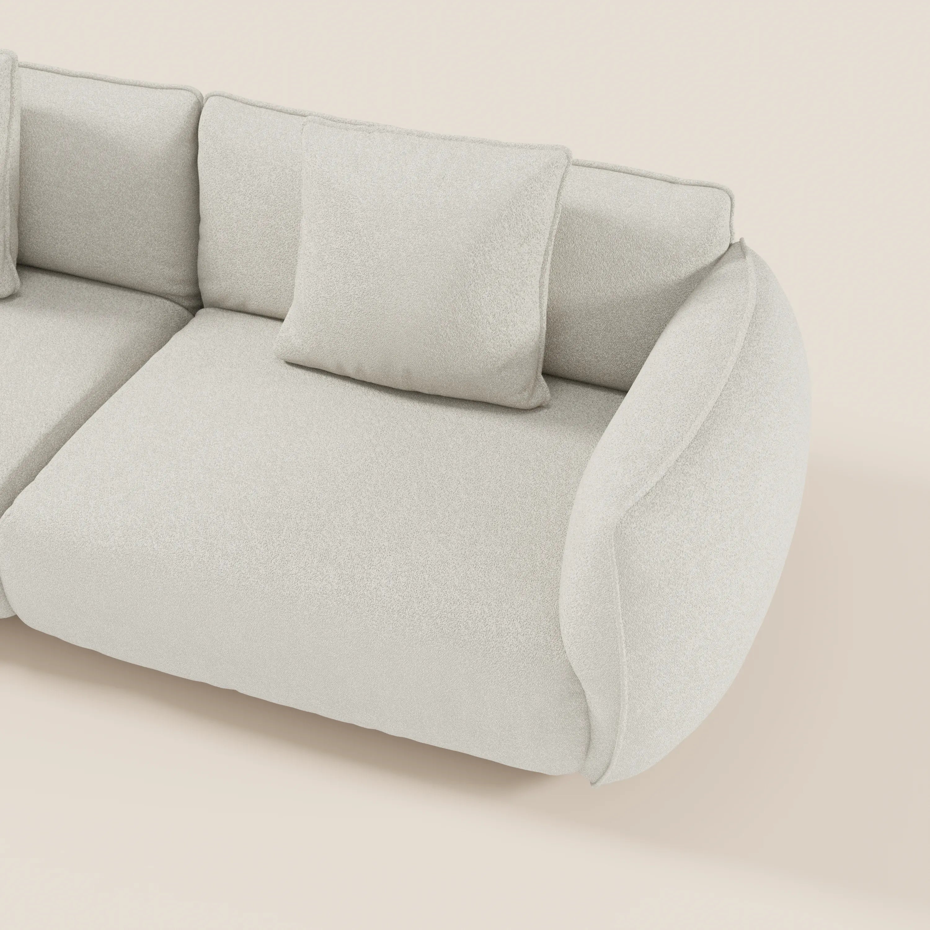 Il divano Nimbus 3 posti modulare e componibile di Divani.Store è caratterizzato da un tessuto in cotone effetto smacchiabile t33, bordi arrotondati e due cuscini di schienale per un look accogliente e minimalista, mostrato in alto su uno sfondo beige chiaro.