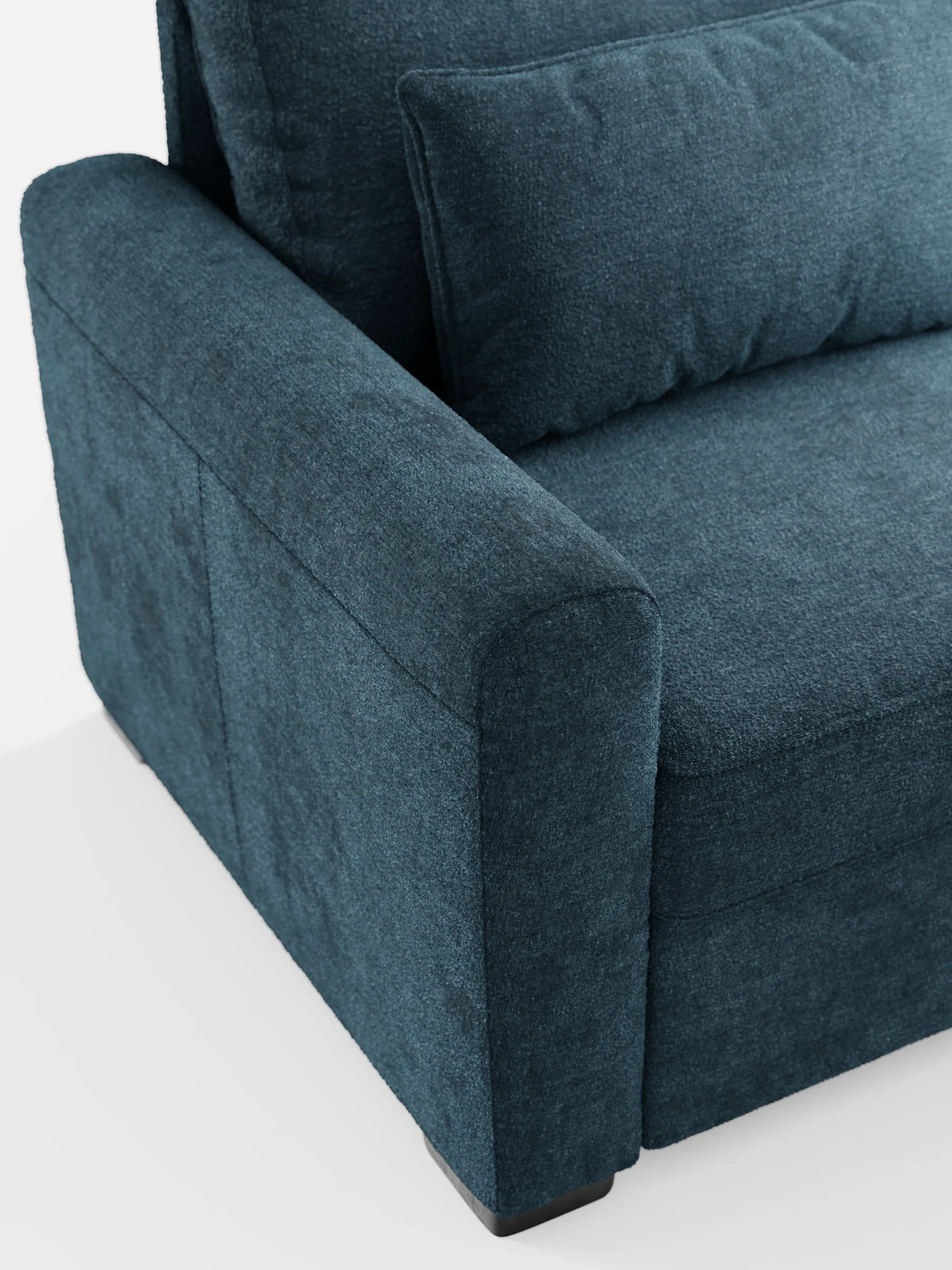 Un primo piano del divano letto Ottaviano in verde acqua scuro con letto estraibile, penisola reversibile e contenitore in tessuto materico lavabile, che mette in risalto i braccioli arrotondati e i cuscini dello schienale rettangolari su uno sfondo bianco.