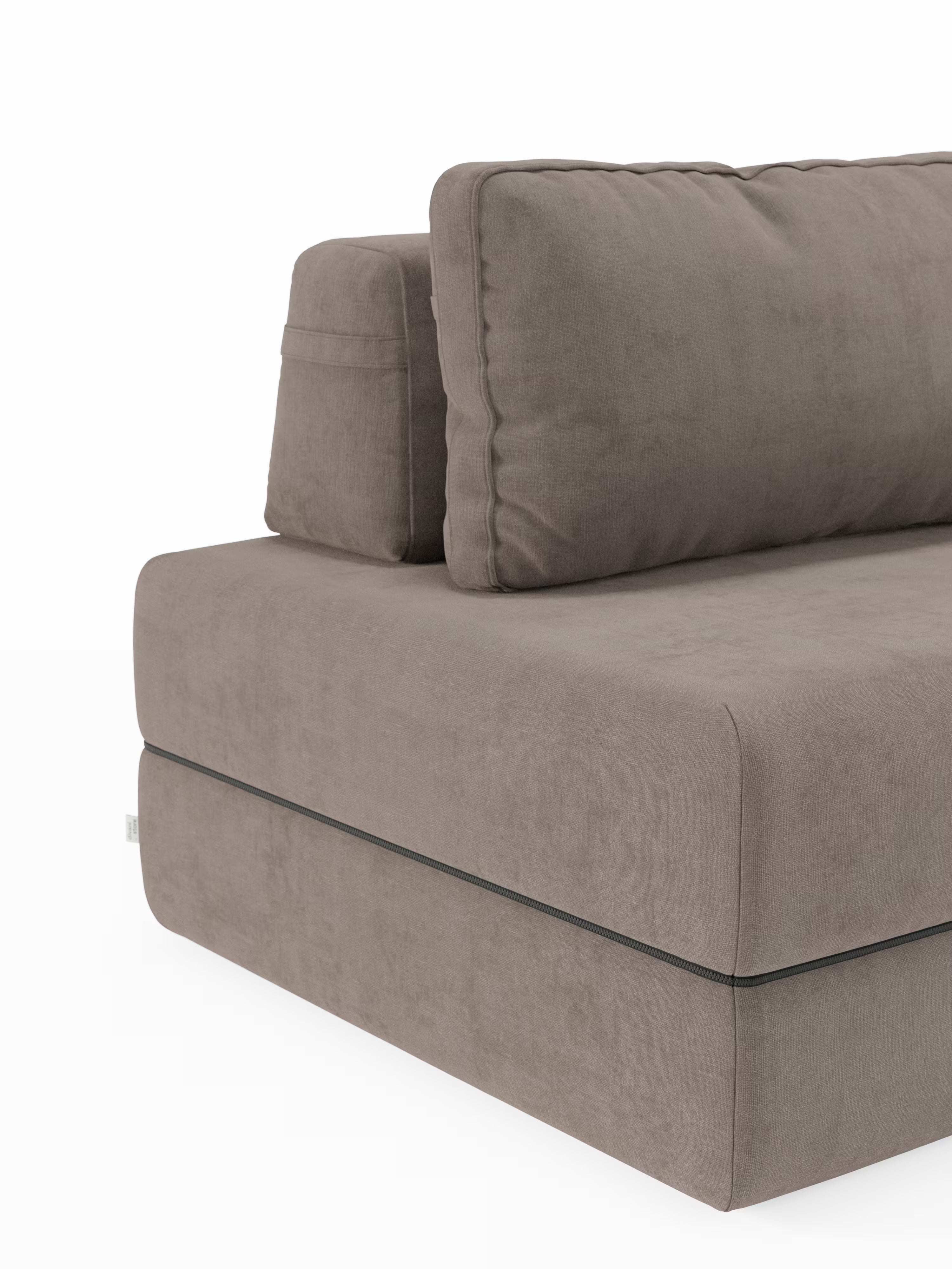 Un primo piano della poltrona letto Rift con materasso alto 22 cm e memory foam di Divani.Store, caratterizzata da un'imbottitura morbida e da linee pulite e minimaliste. Rivestito in morbido tessuto T31 resistente alle macchie e dotato di schienale mobile, questo moderno divano componibile color tortora risalta sullo sfondo bianco, mettendo in risalto la sua seduta spessa e il design contemporaneo ispirato allo stile classico delle poltrone letto.