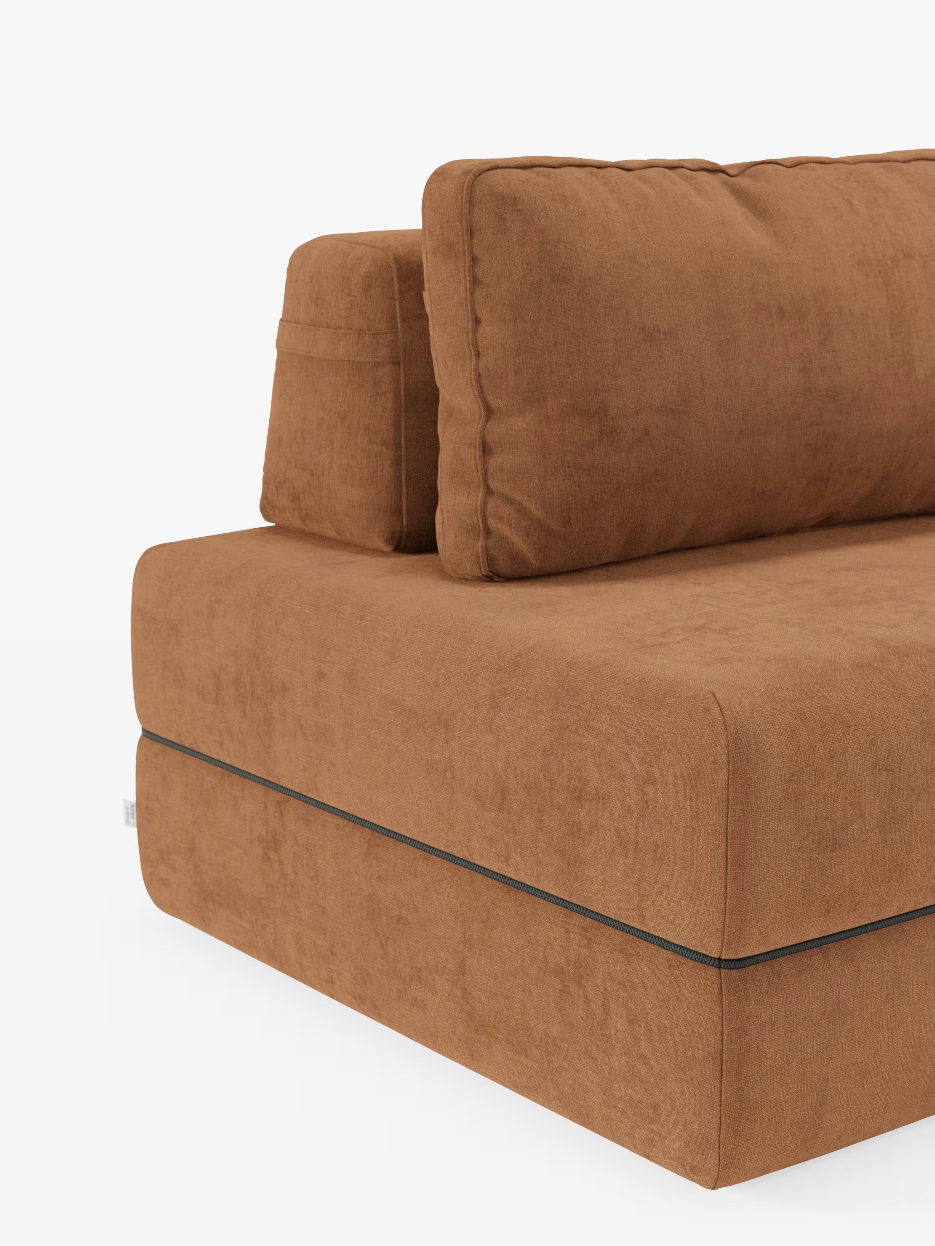 Un primo piano della poltrona letto Rift di Divani.Store con materasso alto 24 cm e memory foam: un’elegante poltrona letto imbottita di colore marrone, caratterizzata da cuscini spessi e rettangolari, un morbido tessuto T31 resistente alle macchie e uno schienale mobile. È visibile solo un angolo, che mette in risalto le linee pulite e il design minimalista su uno sfondo bianco a tinta unita: un vero esempio di poltrona letto trasformabile con schienale mobile, ideale per ogni spazio contemporaneo.