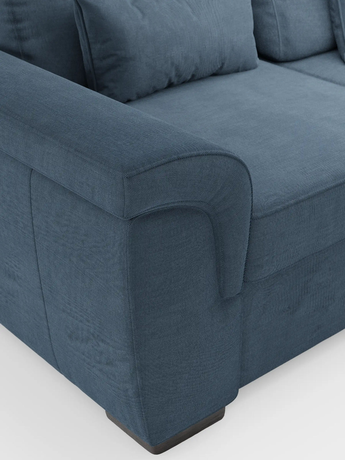 Il divano Ischia a tre posti con pouf estraibile e schienali traslanti in tessuto misto lino smacchiabile è un divano a tre posti blu scuro, dalla trama ruvida, con braccioli ricurvi, cuscini dello schienale coordinati e piedini rettangolari bassi su uno sfondo neutro.
