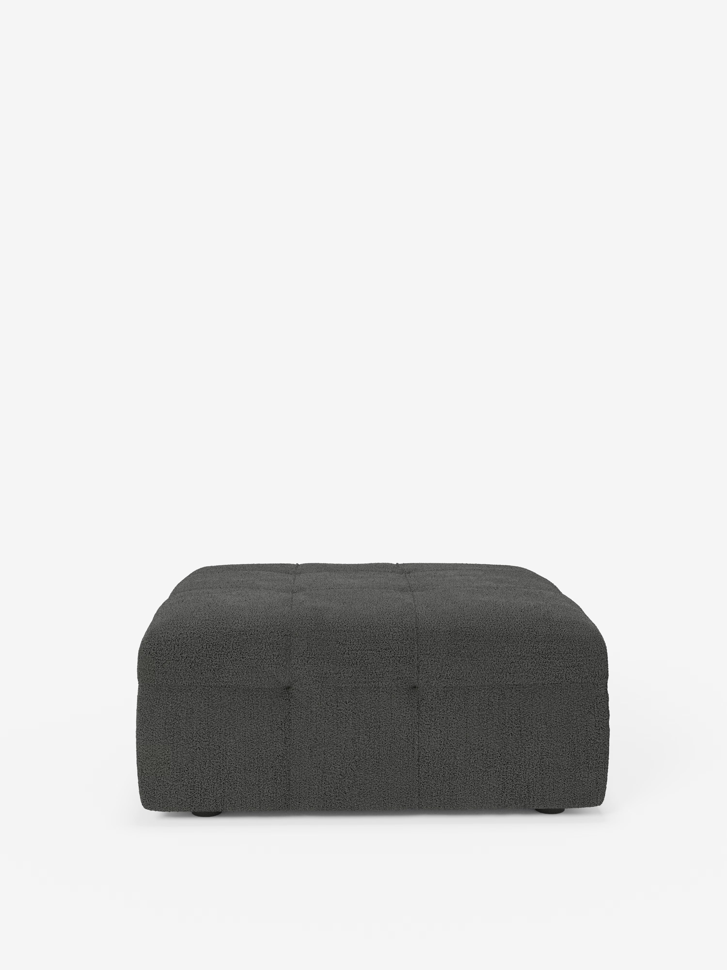 Un pouf quadrato della linea Mosaic di Divani.Store, dalle dimensioni di 96x77 cm, è rivestito in tessuto bouclé grigio scuro antimacchia (T21) con lavorazione capitonné. Caratterizzato dall’assenza di gambe a vista e da linee pulite, questo pouf moderno e minimalista si staglia su uno sfondo bianco.