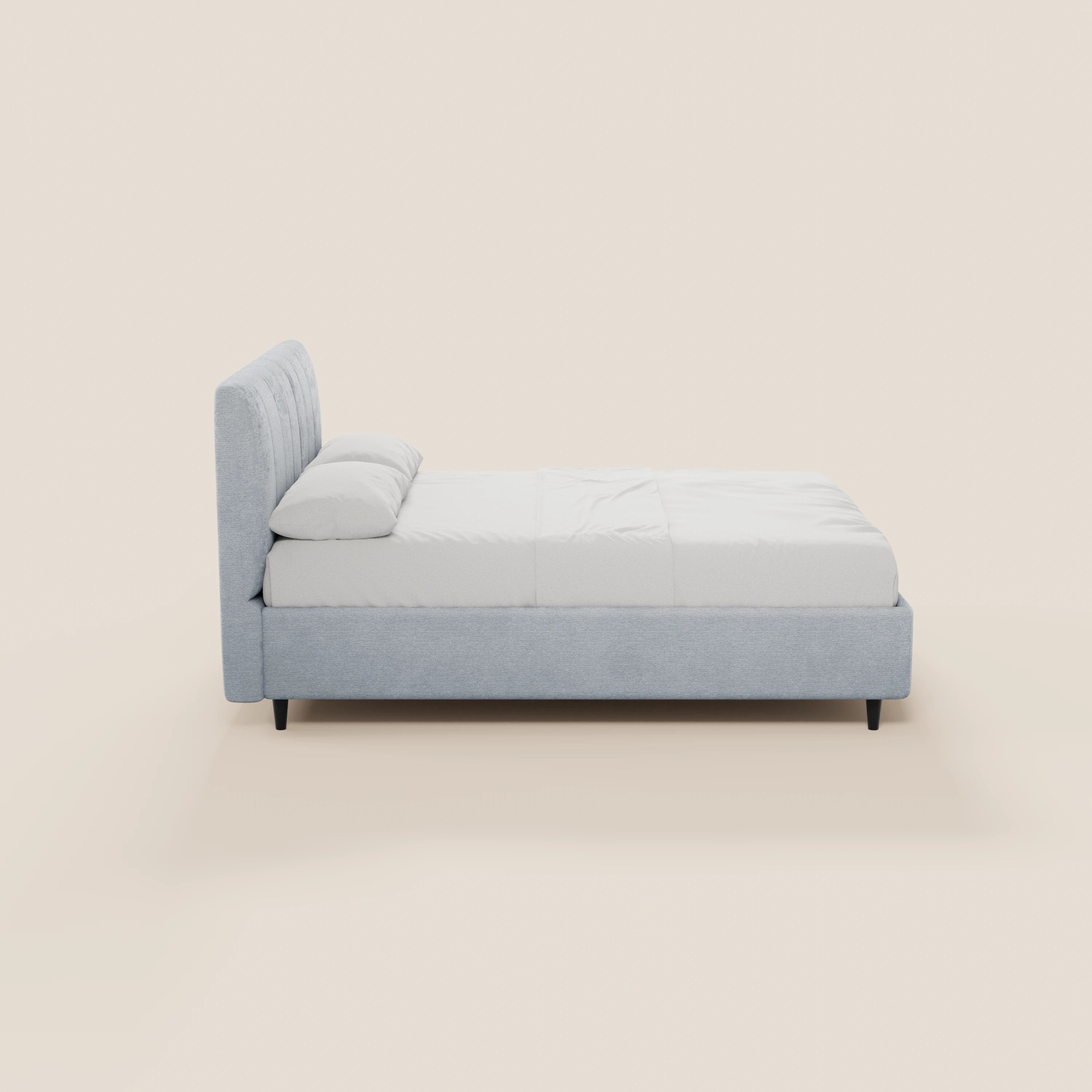 Il letto imbottito ONYX con contenitore e testiera verticale in tessuto Oeko-Tex® di Letti.store presenta un design moderno in grigio chiaro, una testiera alta, biancheria da letto bianca, due cuscini e gambe corte nere su uno sfondo beige chiaro.