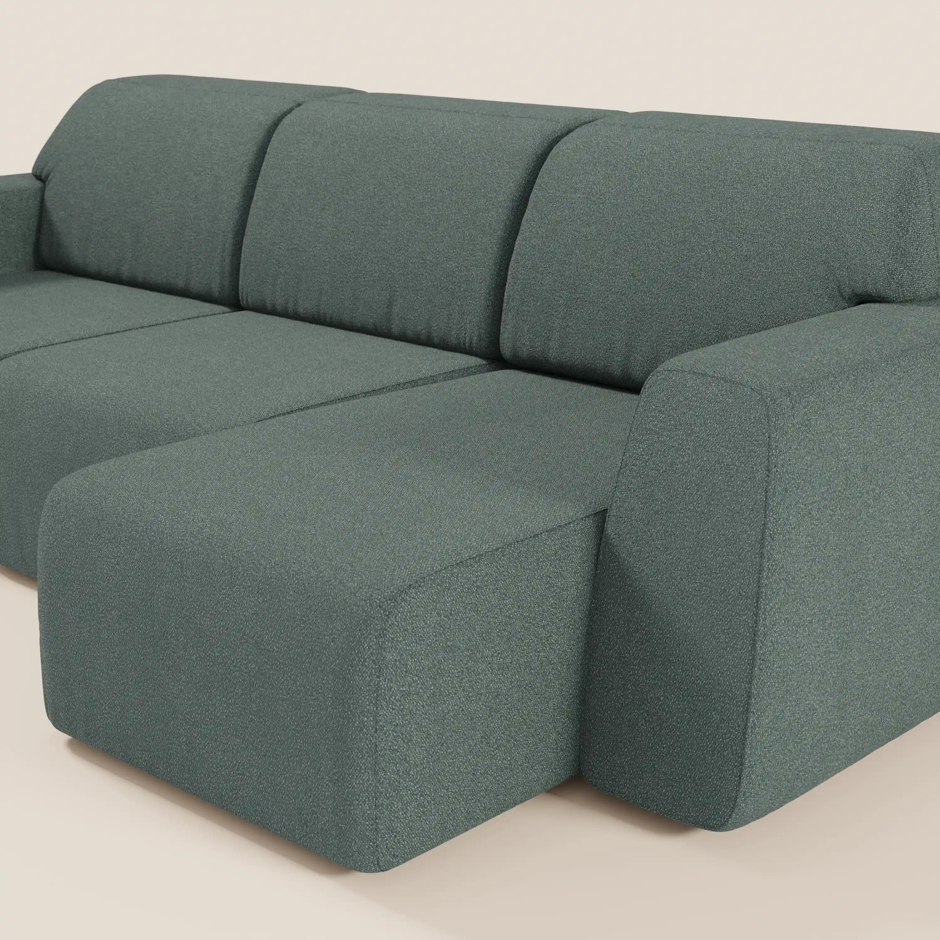 Il divano Orbit di Divani.Store ha 3 sedute scorrevoli e allungabili in tessuto T33 antimacchia effetto cotone, design minimalista, ampi braccioli, cuscini spaziosi e pouf coordinato, il tutto in grigio-verde testurizzato su sfondo beige chiaro.