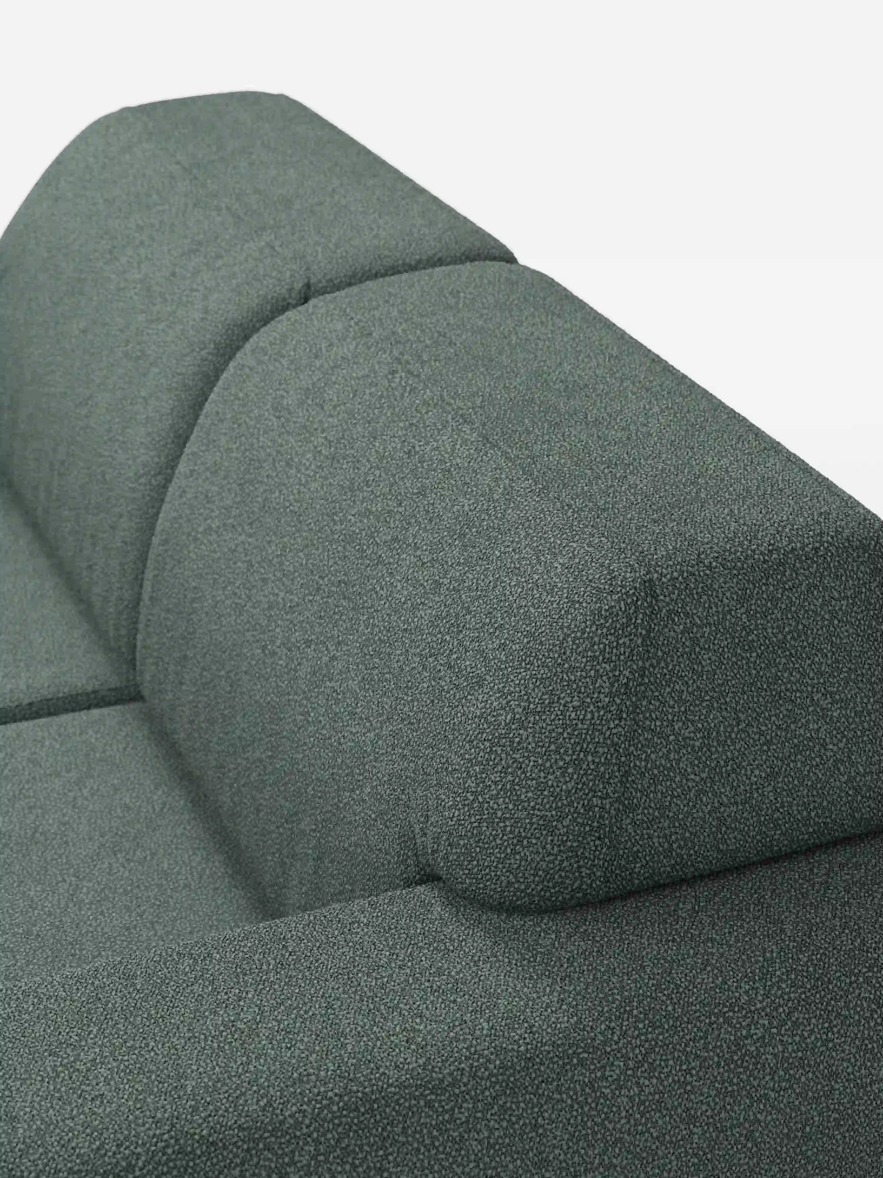 Primo piano del divano Orbit a 2 e 3 posti con sedute scorrevoli di Divani.Store, rivestito con il tessuto smacchiabile T33 verde testurizzato effetto cotone. L’immagine mette in risalto il suo design pulito e geometrico, caratterizzato da linee rette, uno schienale inclinato e cuciture a vista, su uno sfondo bianco a tinta unita. Completamente sfoderabile e ideale per interni contemporanei.